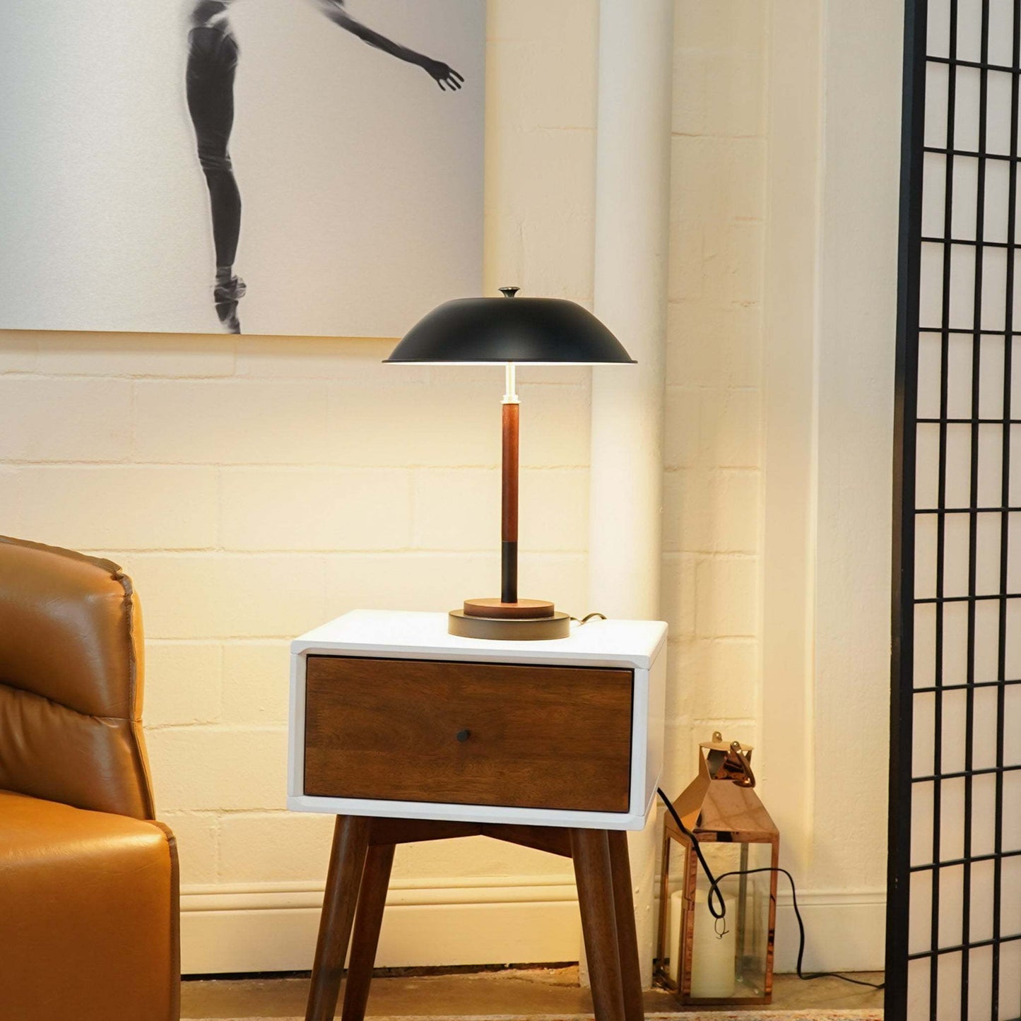 mid century table lamp turned on in a room on top of a side table