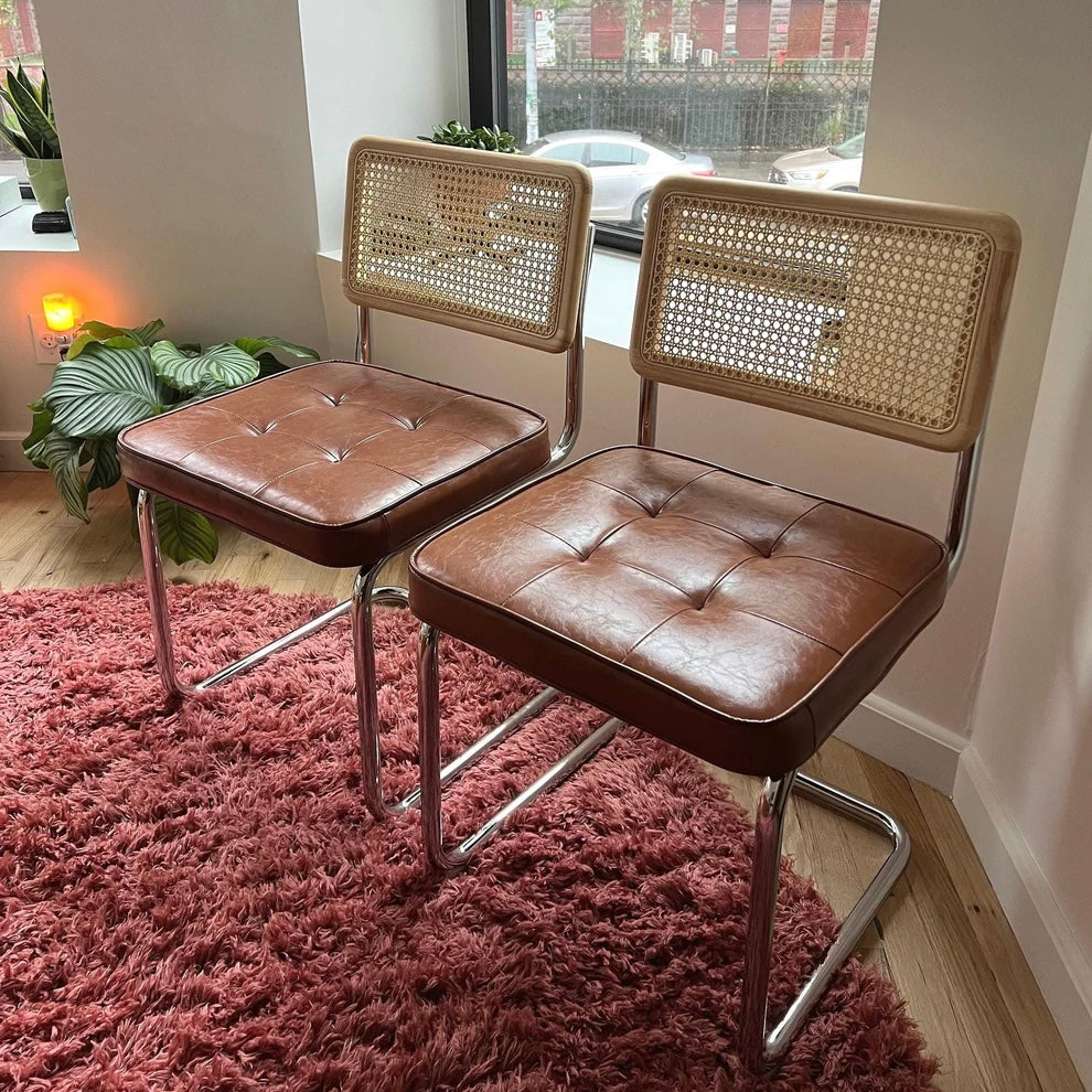 mid century modern dining chairs with brown vegan leather seats solid wood backrests with rattan accents and stainless steel frames