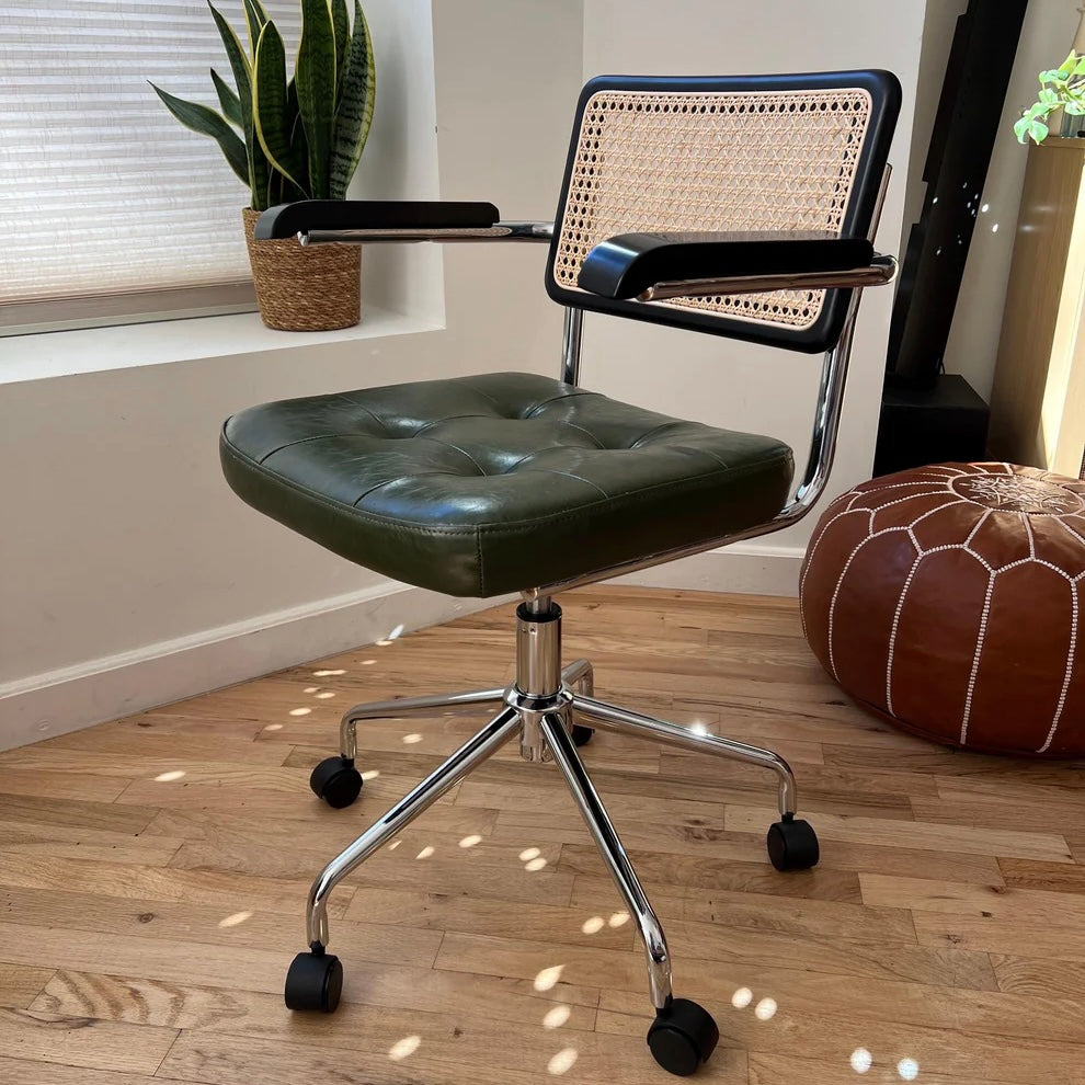 front quarter view of mcm office chair with black stained wood natural rattan green vegan leather and stainless steel frame