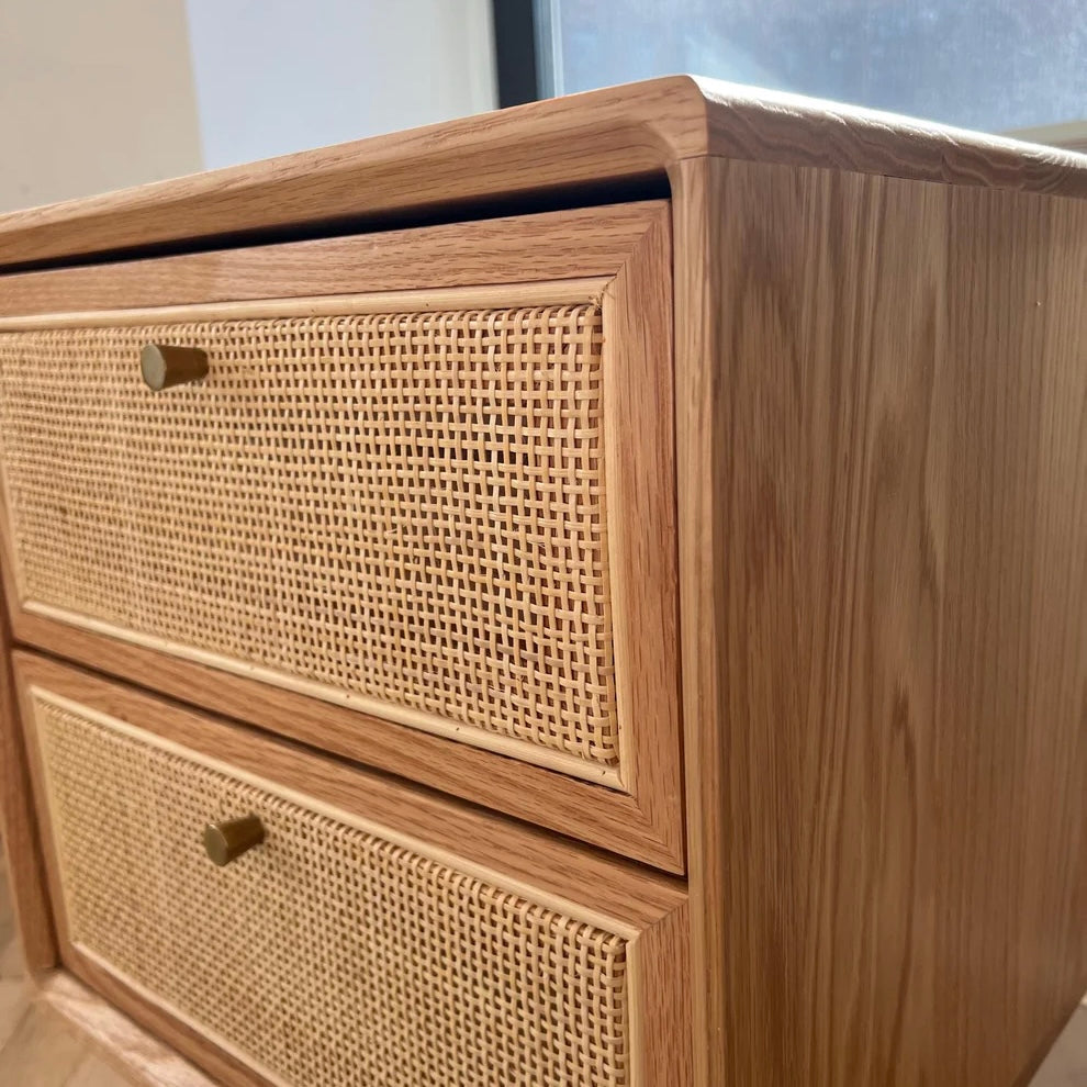 closeup of woodgrain pattern on solid red pine nightstand with natural rattan drawers