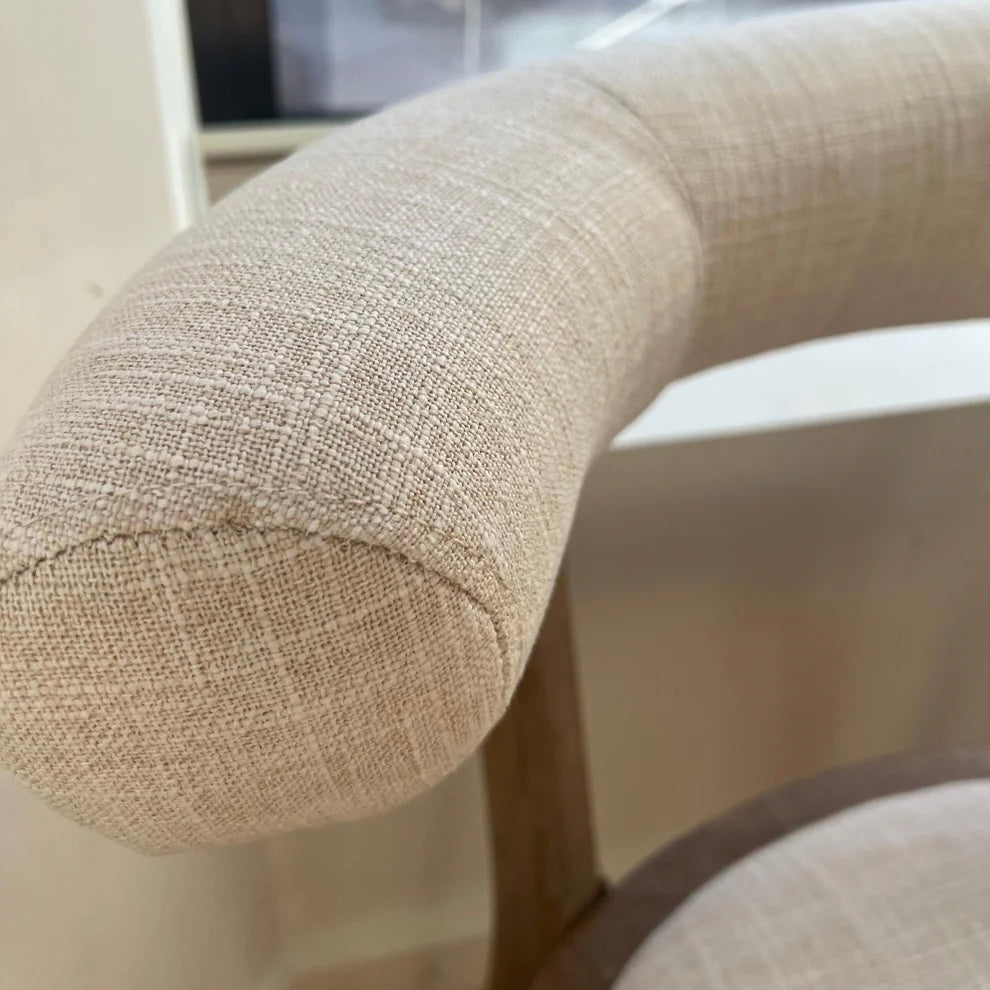 close up of beige linen dining chair with fabric stitching