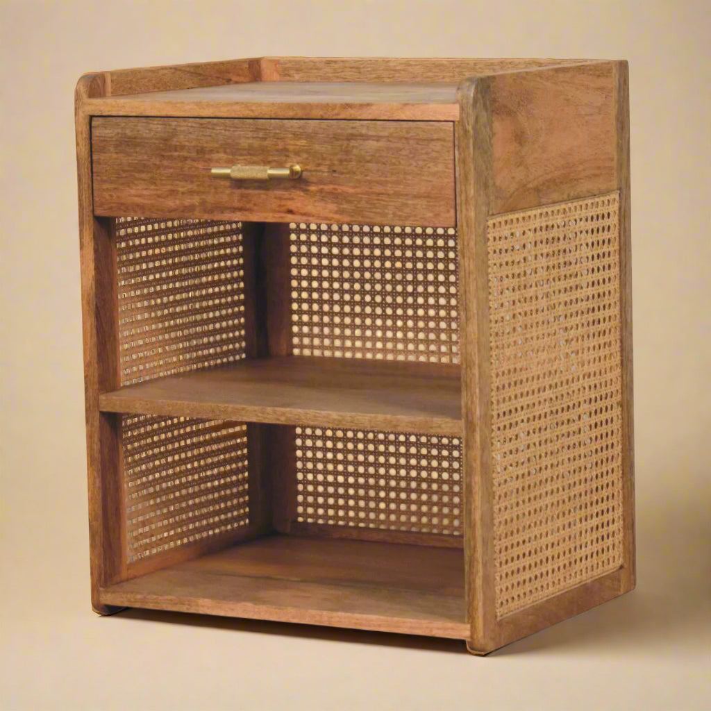 three quarter view of solid mango nightstand showing single drawer, two shelves, and rattan sides and back