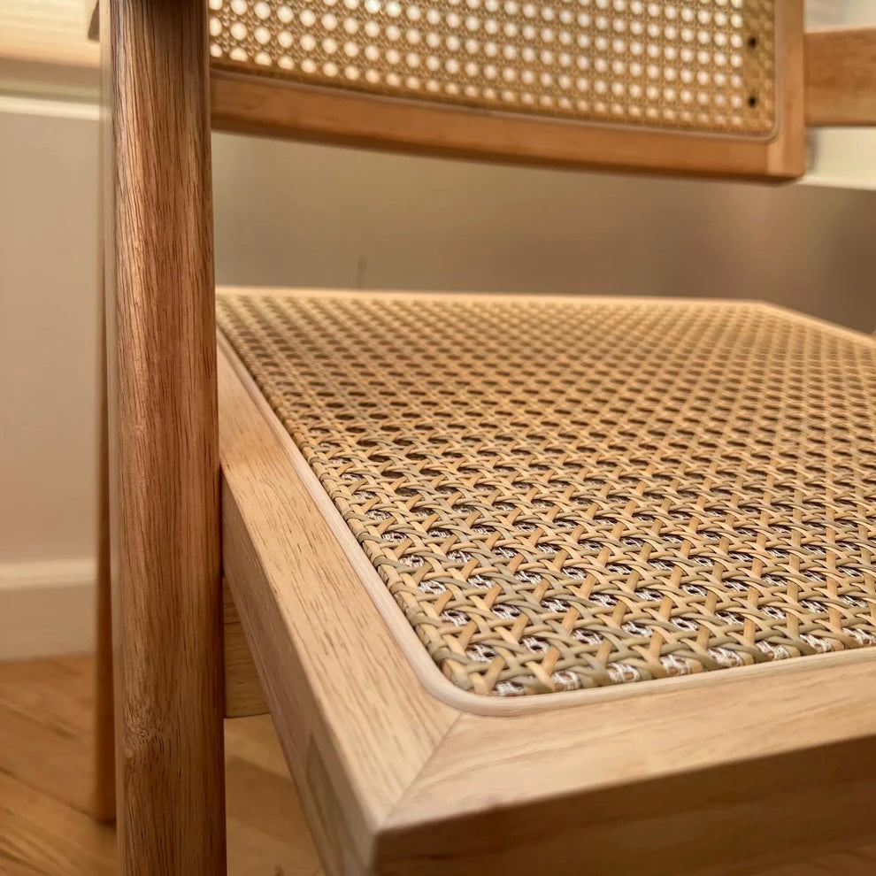 Front side closeup of woodgrain and natural rattan on mcm dining chair