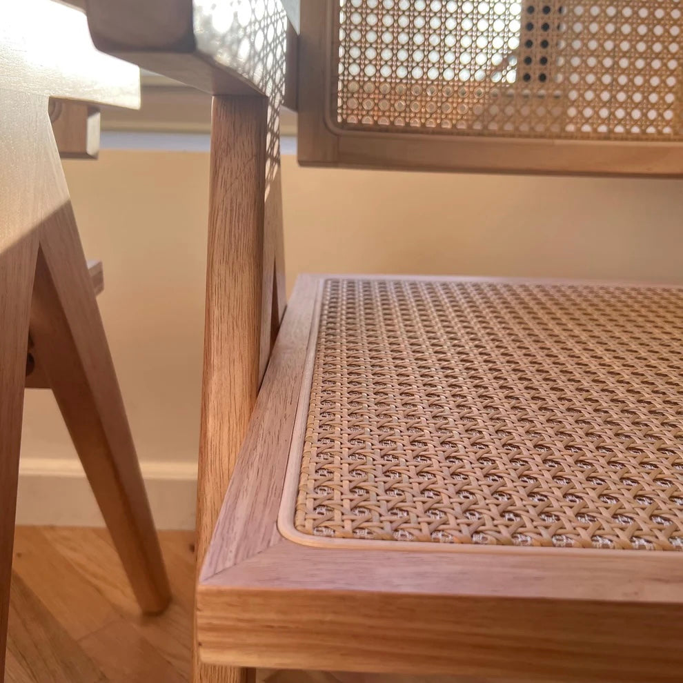 Frontside closeup of natural rattan and stitching inlay on solid wood dining chair