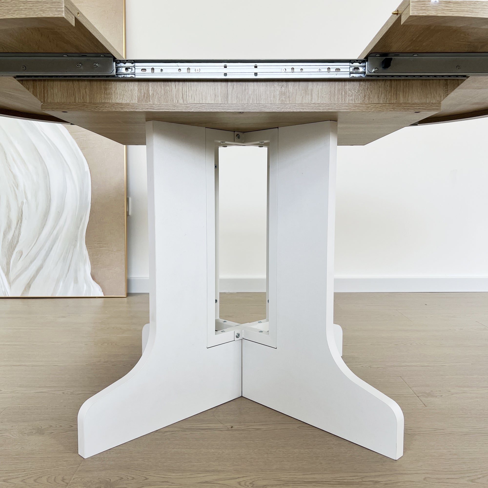 Close-up of the white double-column pedestal base with extension slide rails above