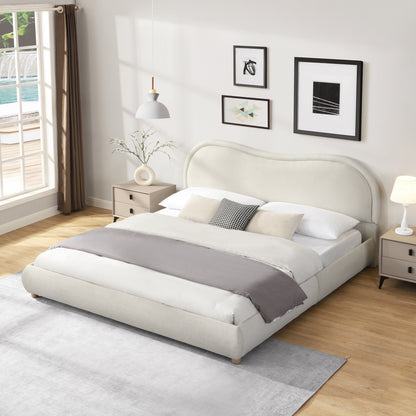 Beige king platform bed in a sunlit bedroom with layered gray and white bedding