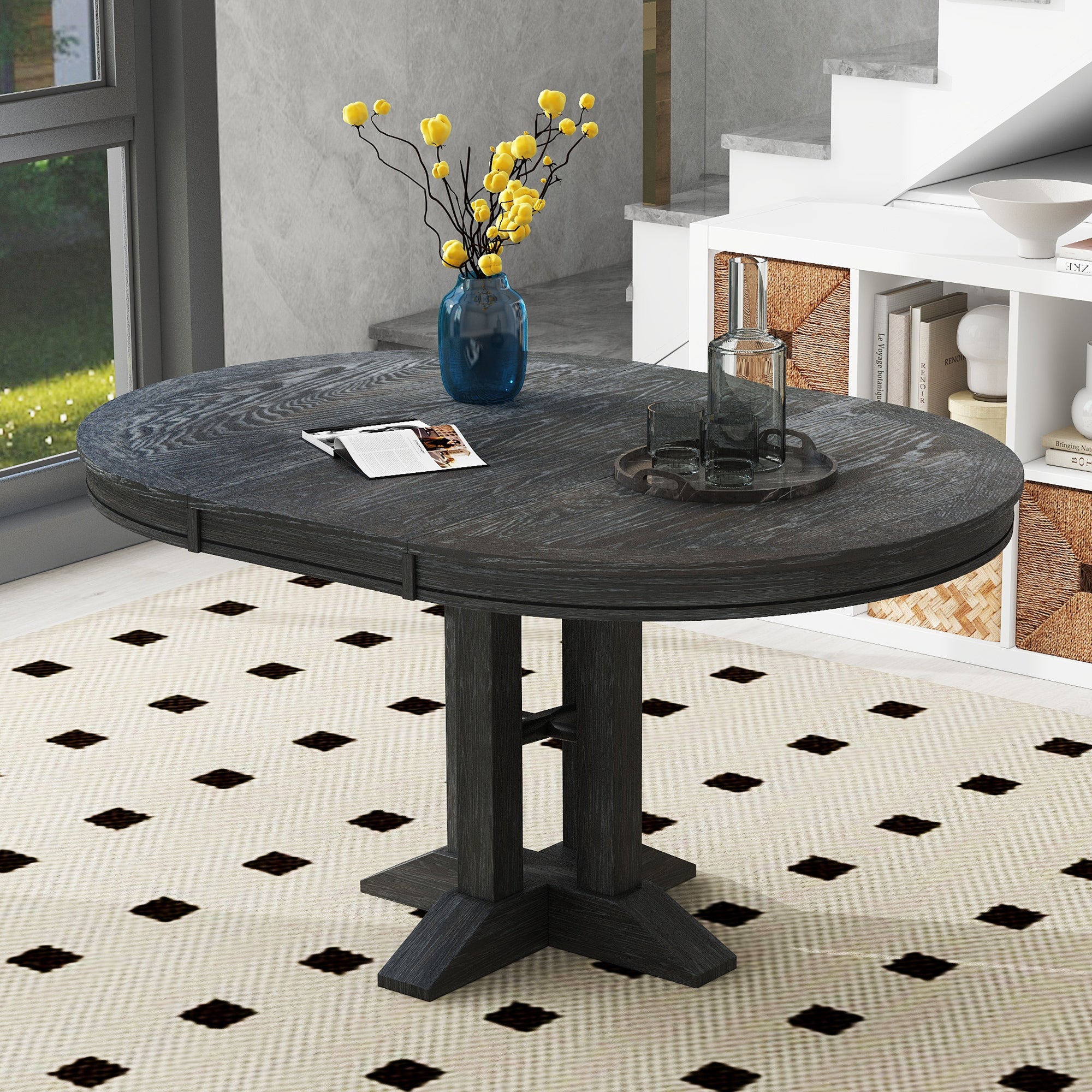 Black oval-extended dining table styled beside a bright window