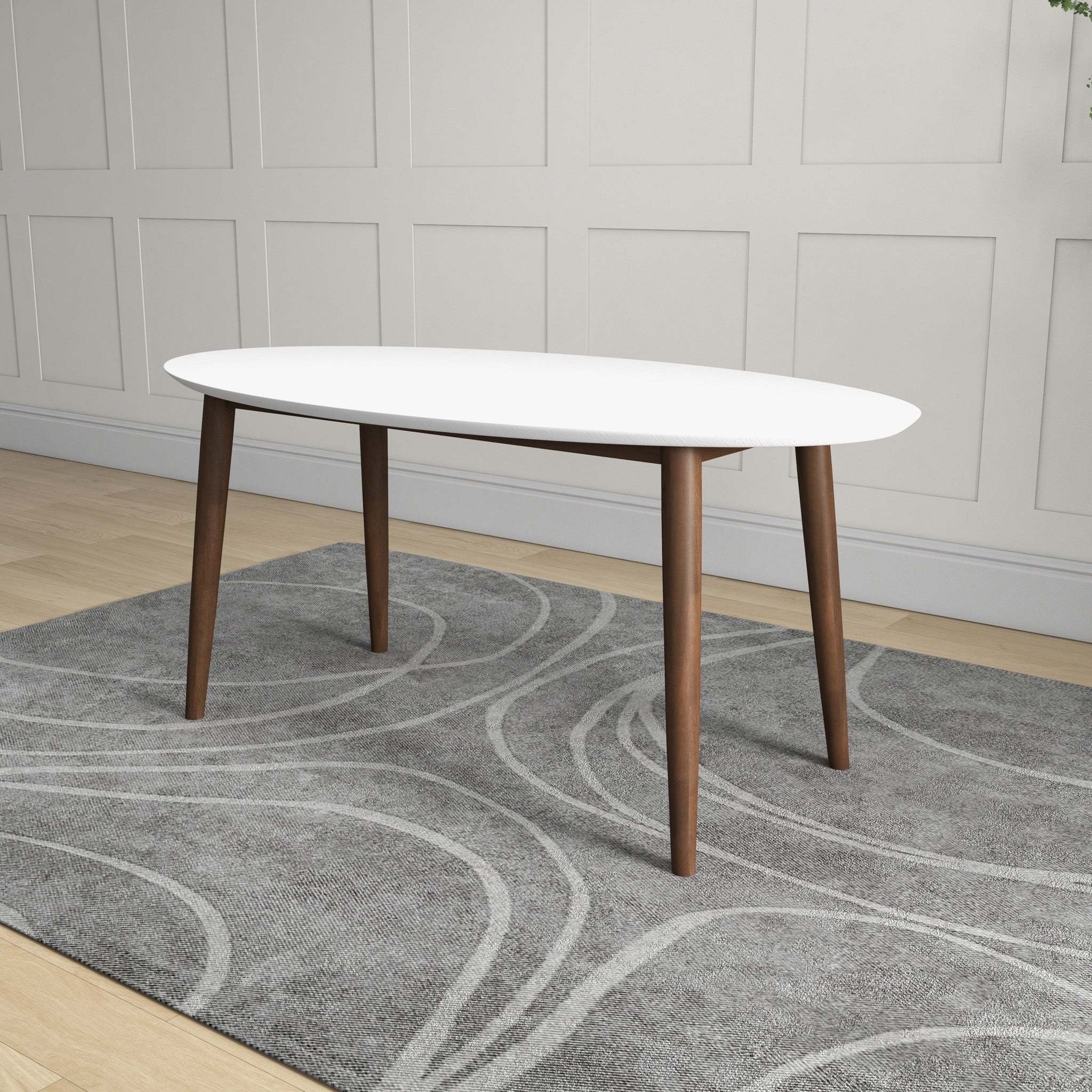 White-top oval dining table styled on a grey rug near a paneled wall