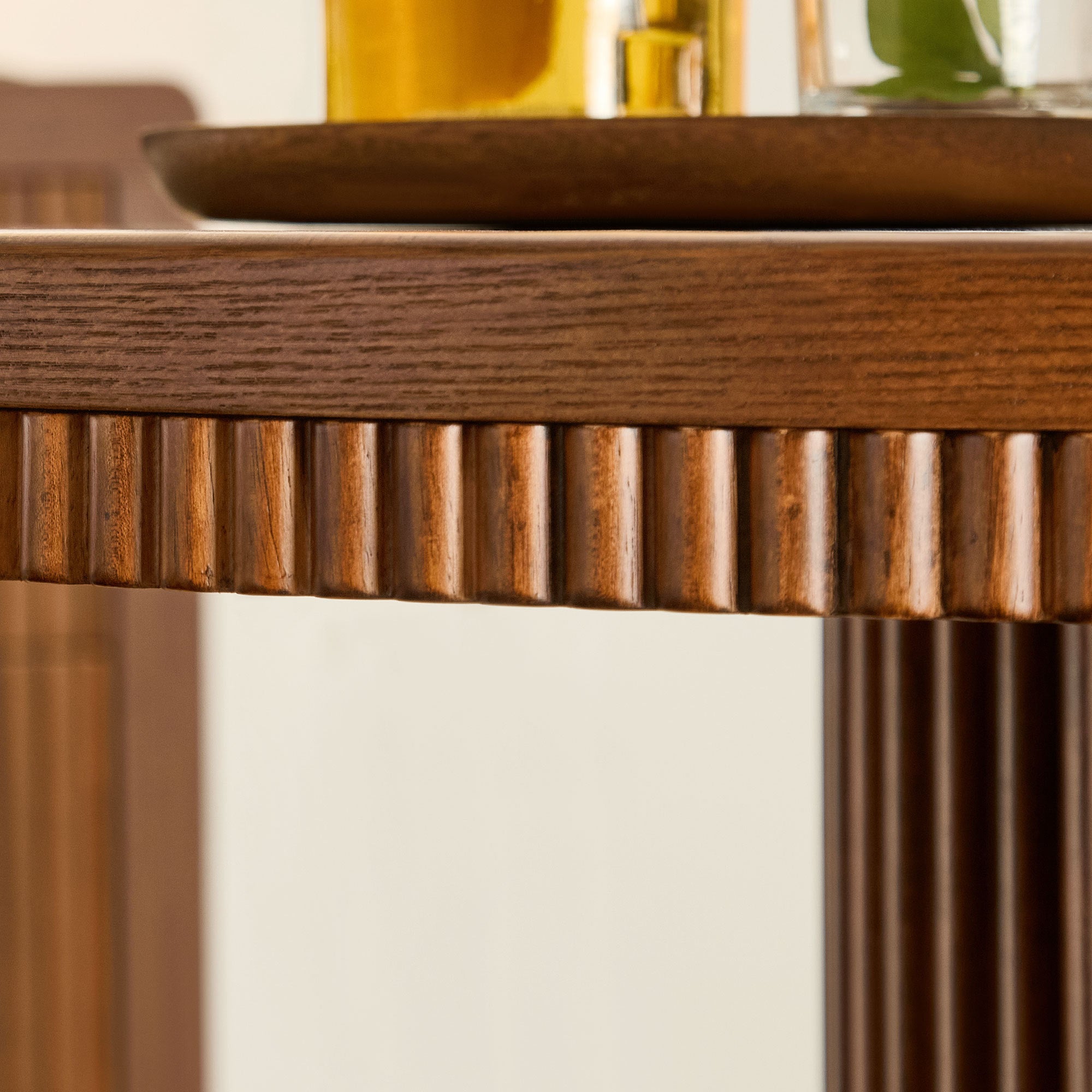 Close-up of the fluted wood apron beneath the round table's stone top