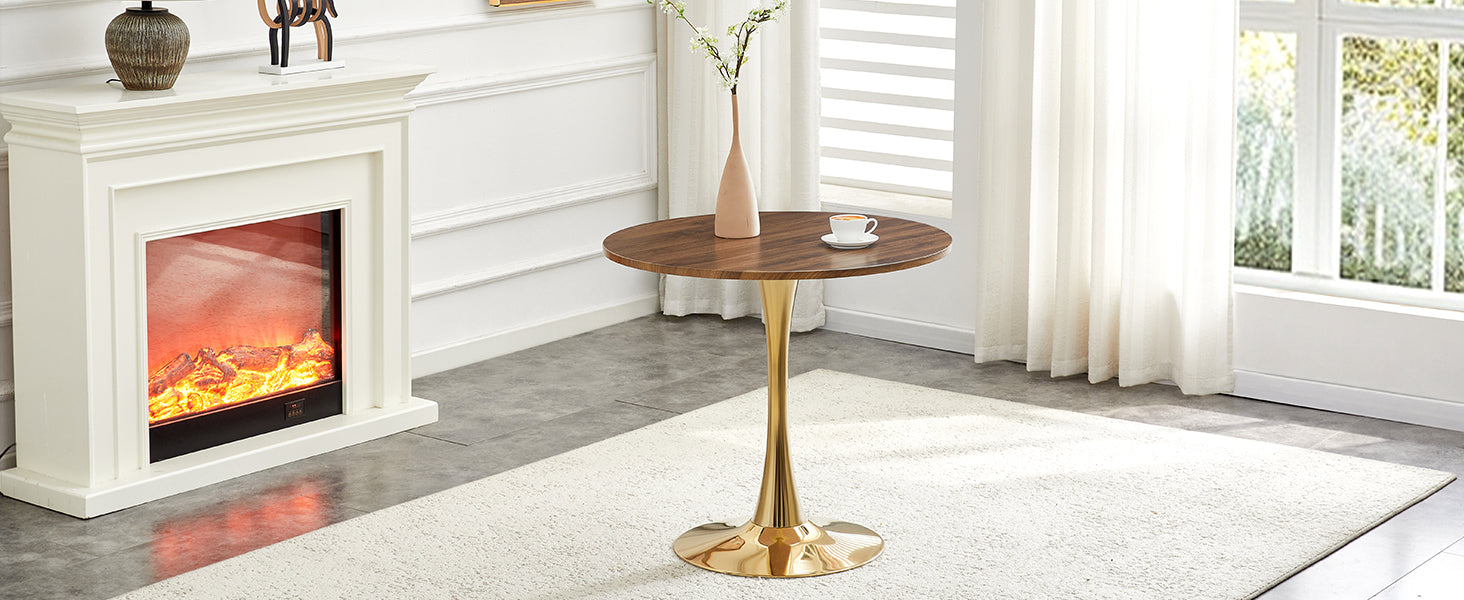 Walnut round dining table with gold pedestal between a fireplace and window, three-quarter view