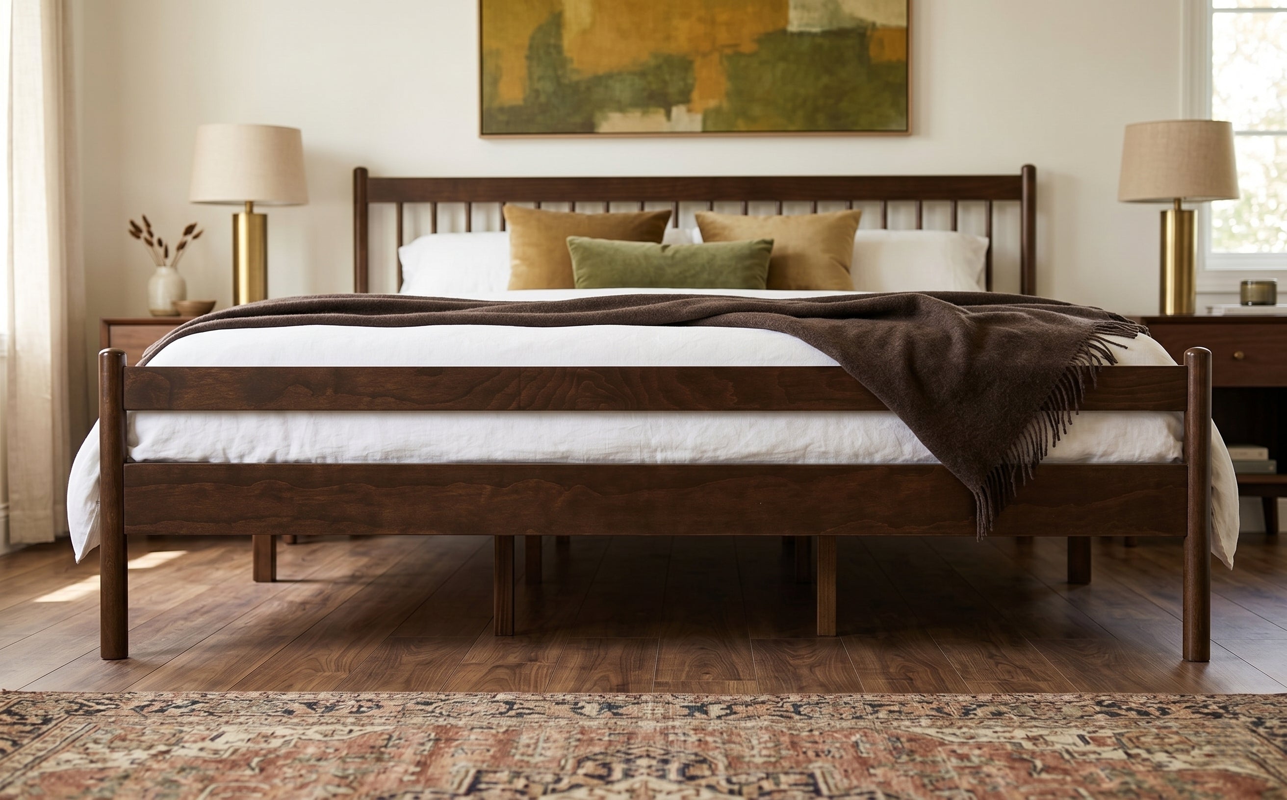 Wide shot of walnut king bed framed by bedside lamps