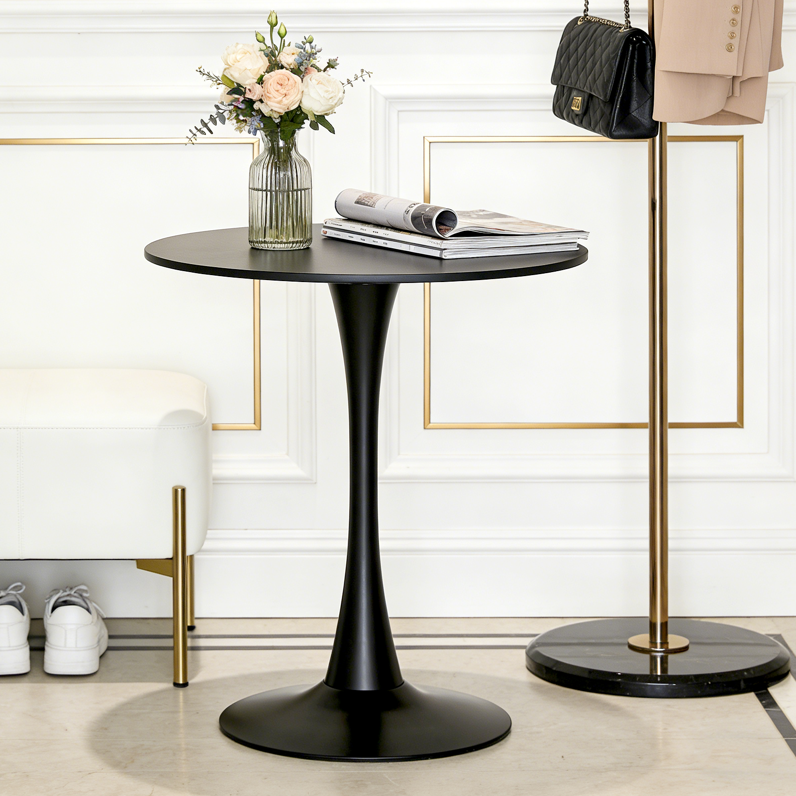 Black modern round dining table with tulip pedestal styled with roses and magazines in an entryway