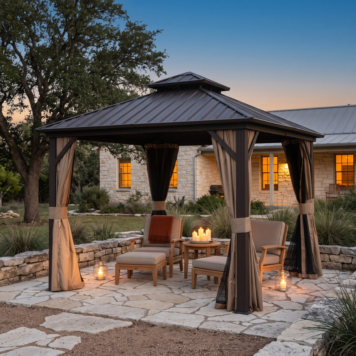 Brown aluminum 10x10 double roof hardtop gazebo with tied back curtains over lounge chairs on a stone patio at dusk