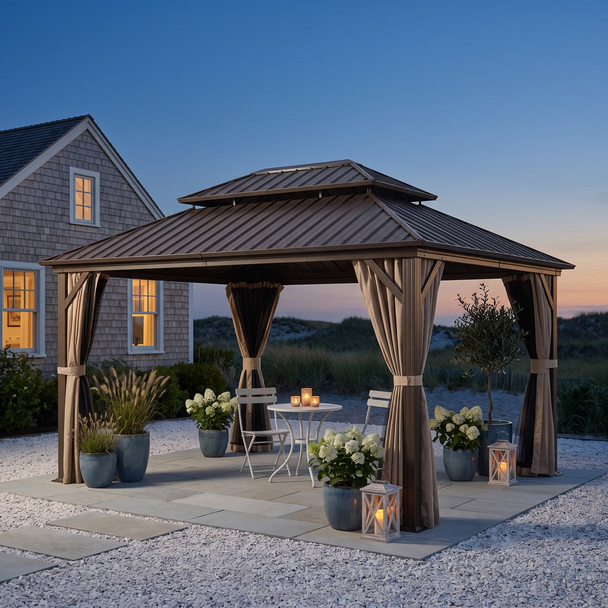 Brown aluminum 12x16 double roof hardtop gazebo with tan curtains over a bistro table on a stone patio at dusk