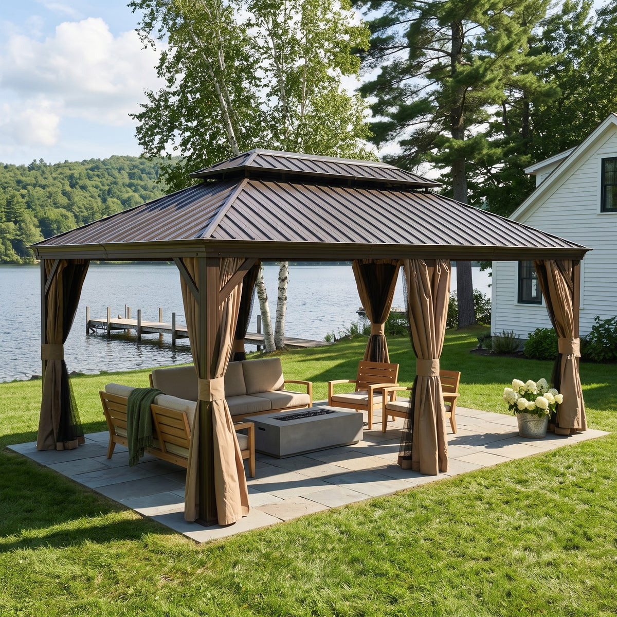 Brown aluminum 12x18 double roof hardtop gazebo with tied back curtains over lounge seating by a lake
