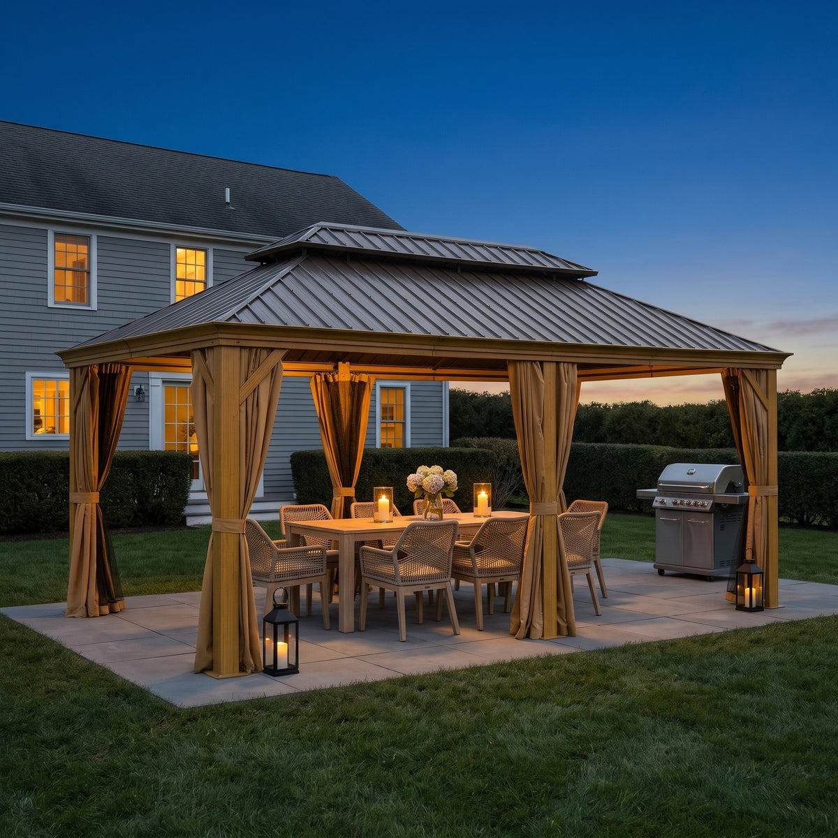 Yellow brown aluminum 12x20 hardtop gazebo with tied back curtains over a dining table on a patio at dusk
