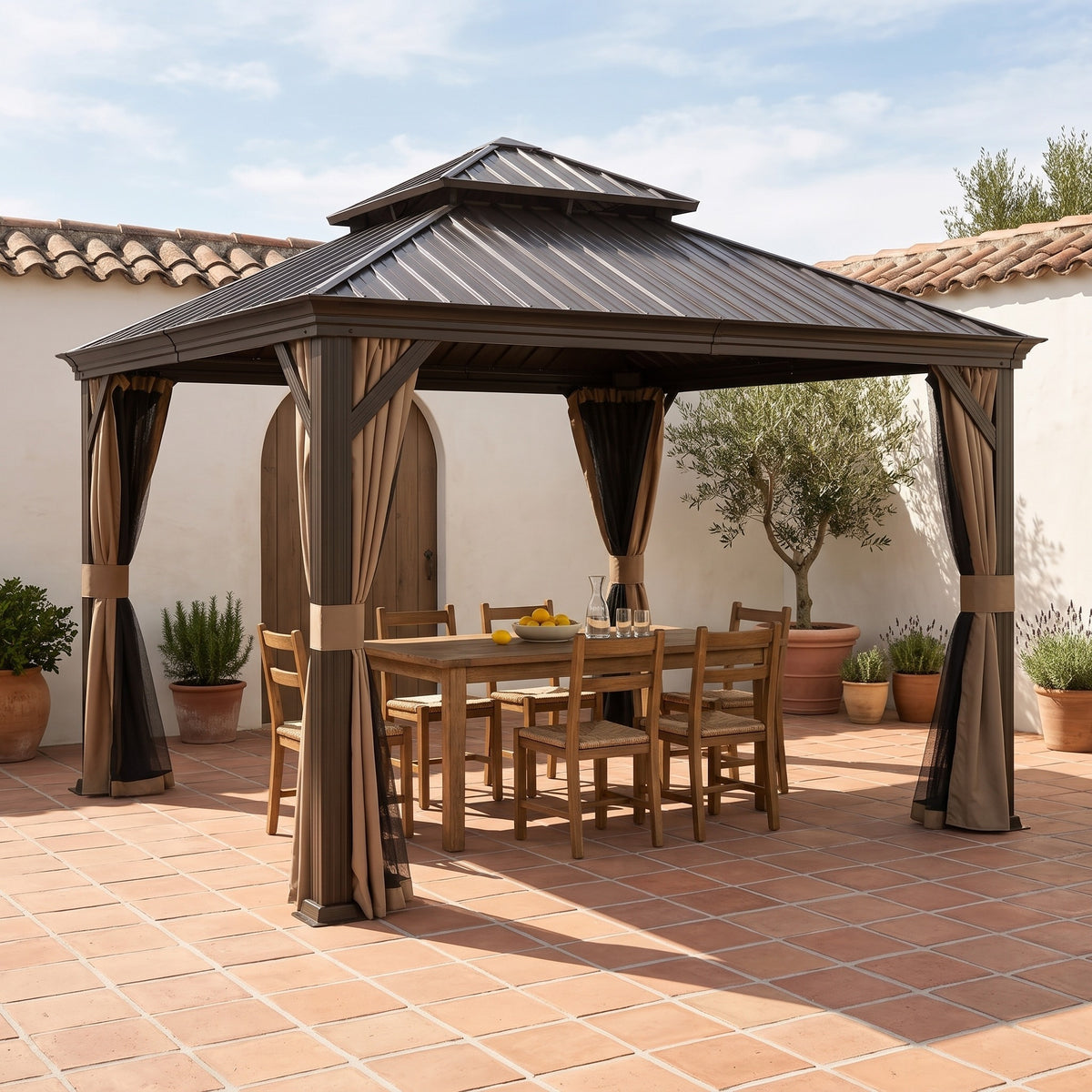 Brown steel 13x13 double roof hardtop gazebo with tan curtains over a wood dining table on a terracotta courtyard