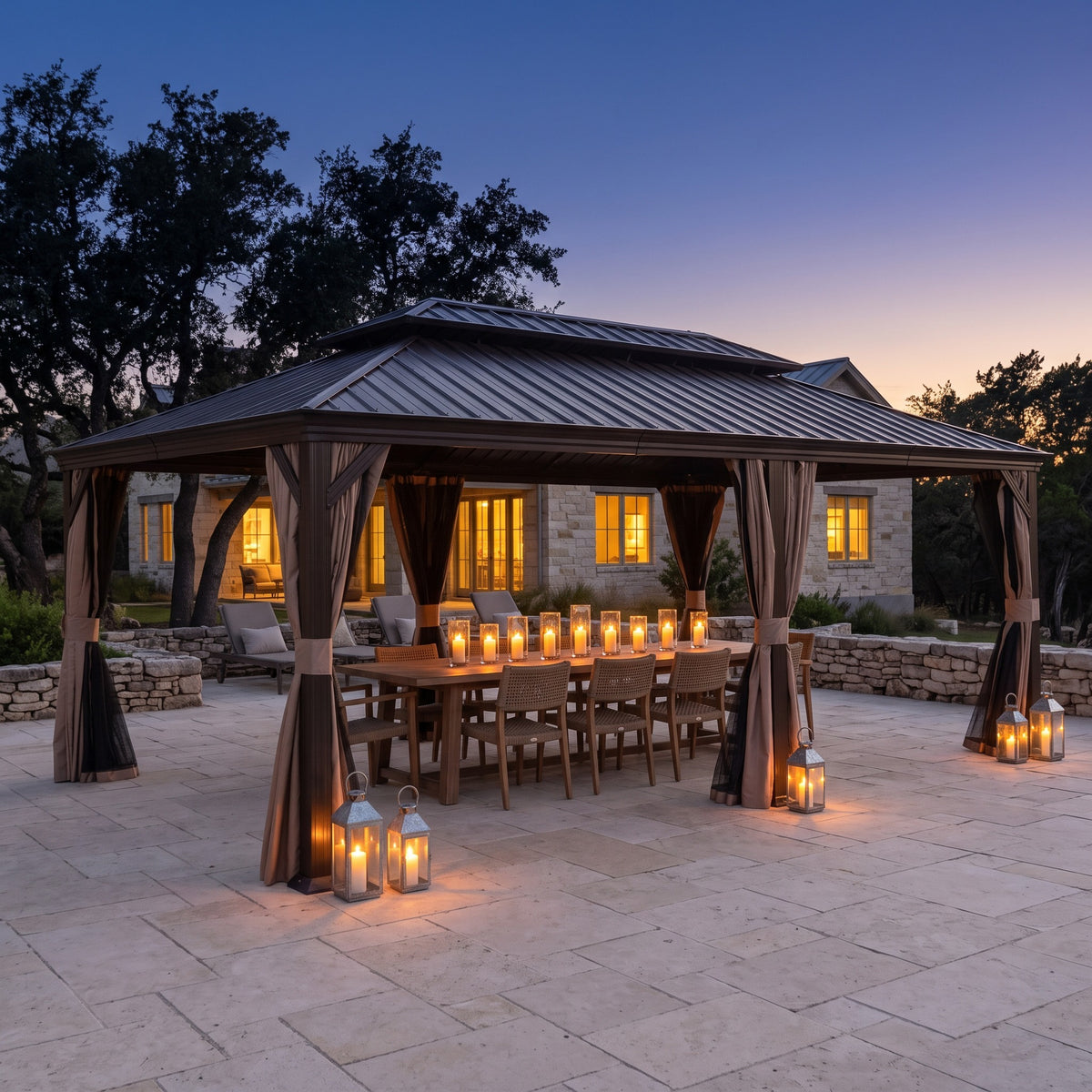 Brown metal 14x22 hardtop gazebo with curtains over a long candlelit dining table on a stone patio at dusk