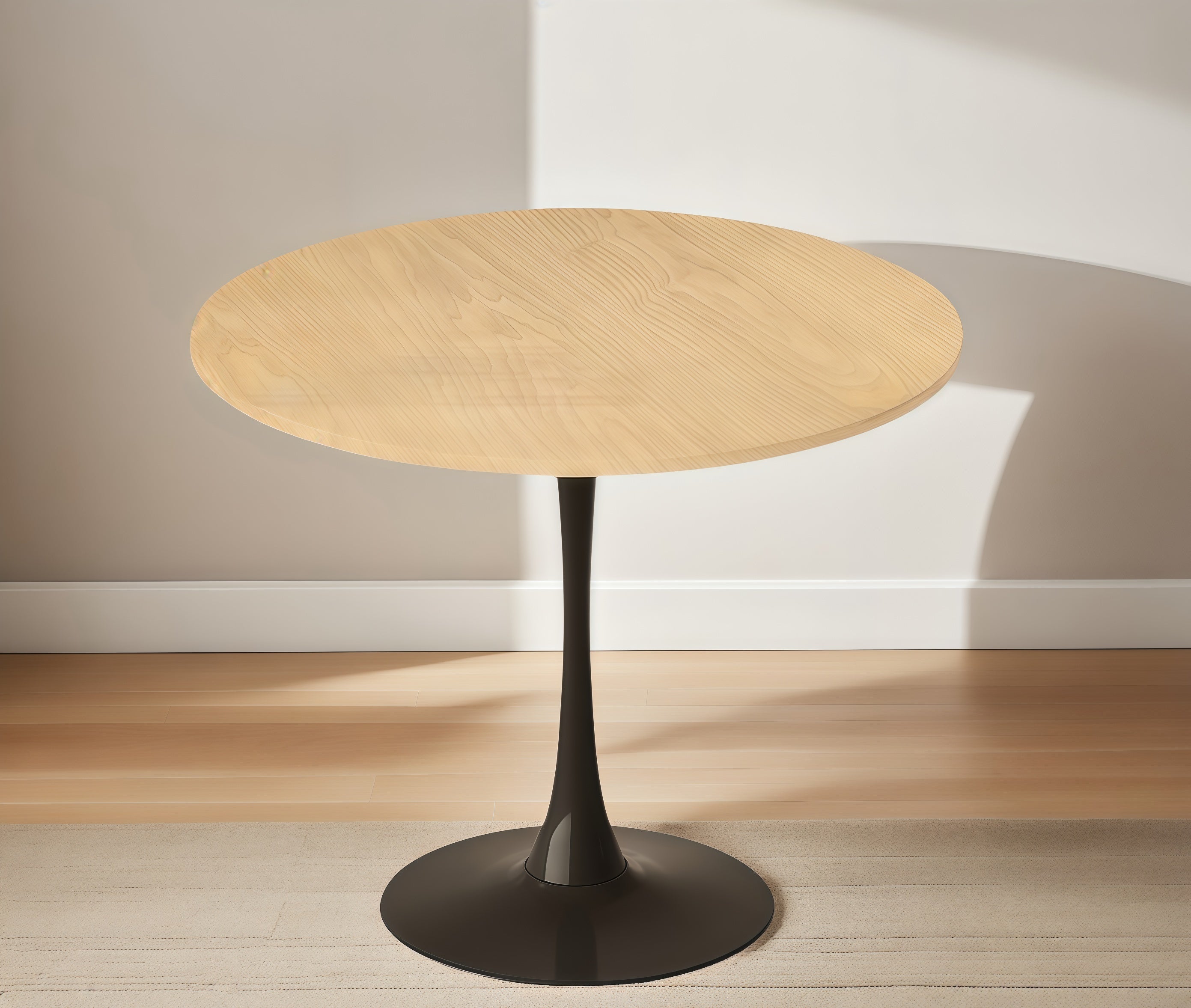 Three-quarter view of the natural wood round bistro table against a pale wall on a wood floor