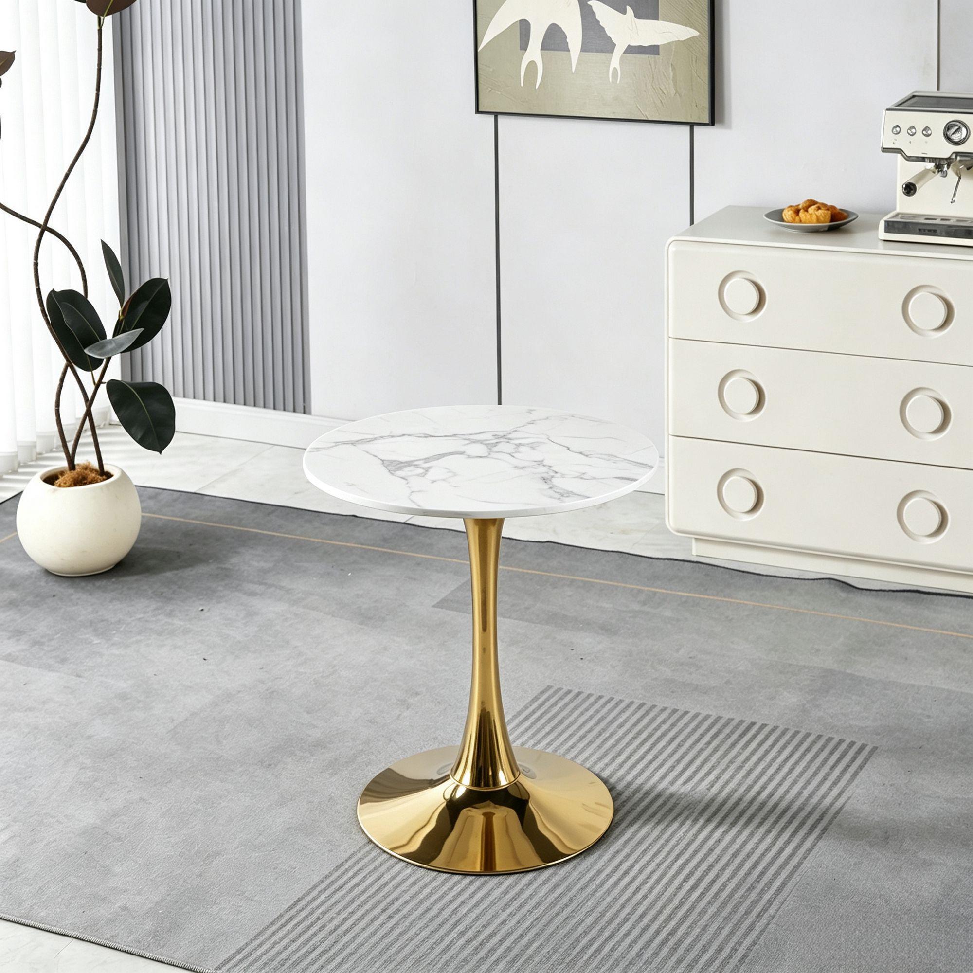 White faux marble tulip dining table styled in a room with a plant, dresser, and espresso machine