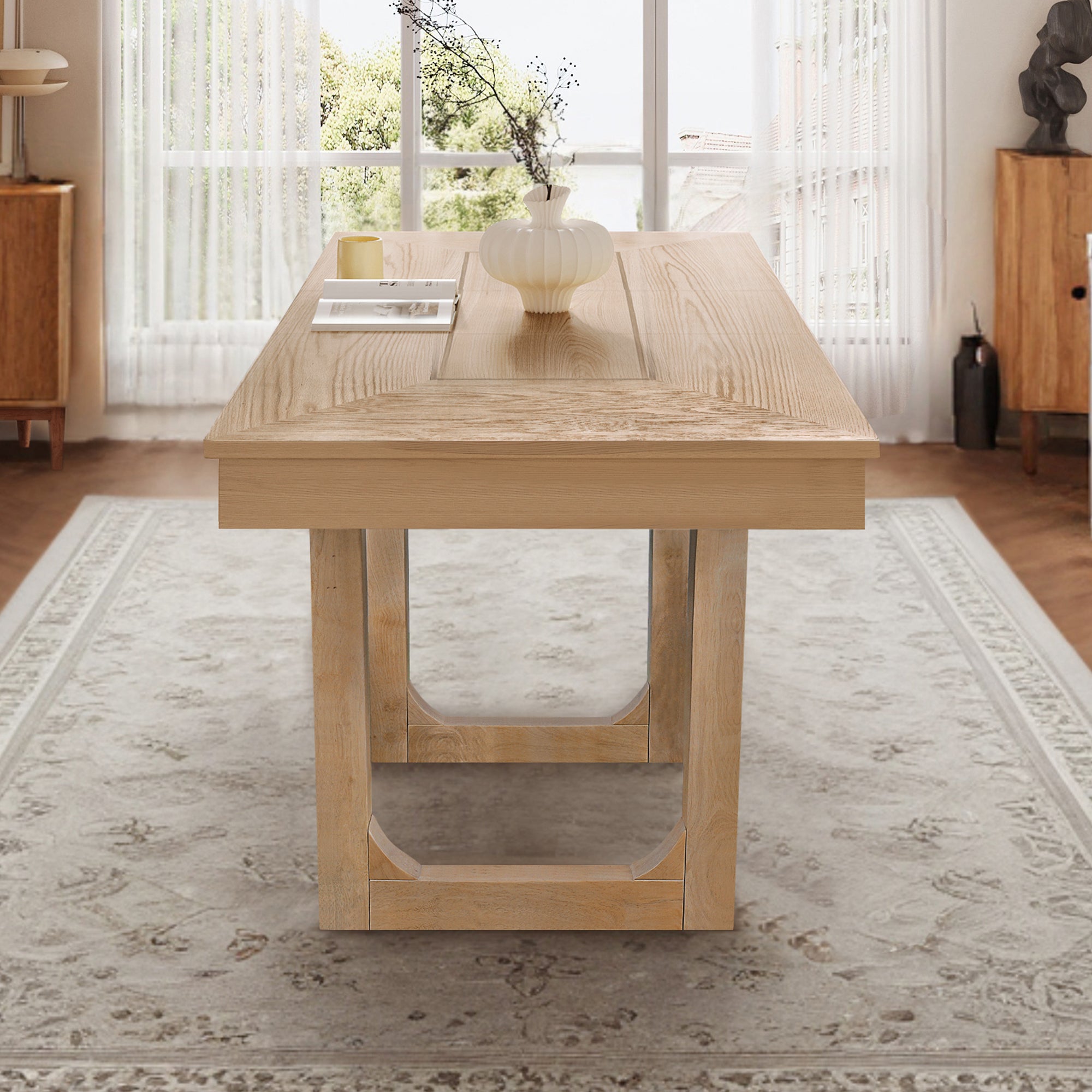 Angled end view of the oak farmhouse dining table styled in a sunlit dining room