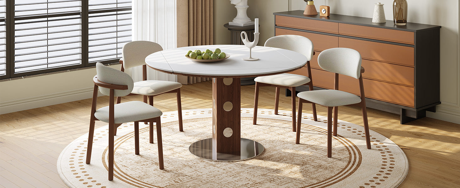 White round folding dining table with four cream chairs and green apples in a bright room