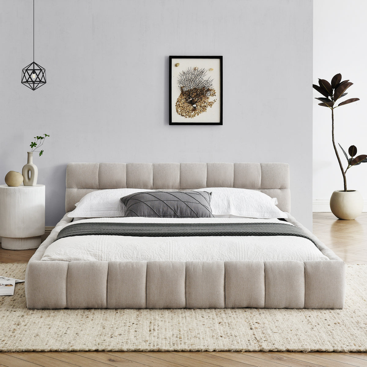 Beige chenille platform bed styled in a bedroom, angled foot view, white bedding and gray accent pillow