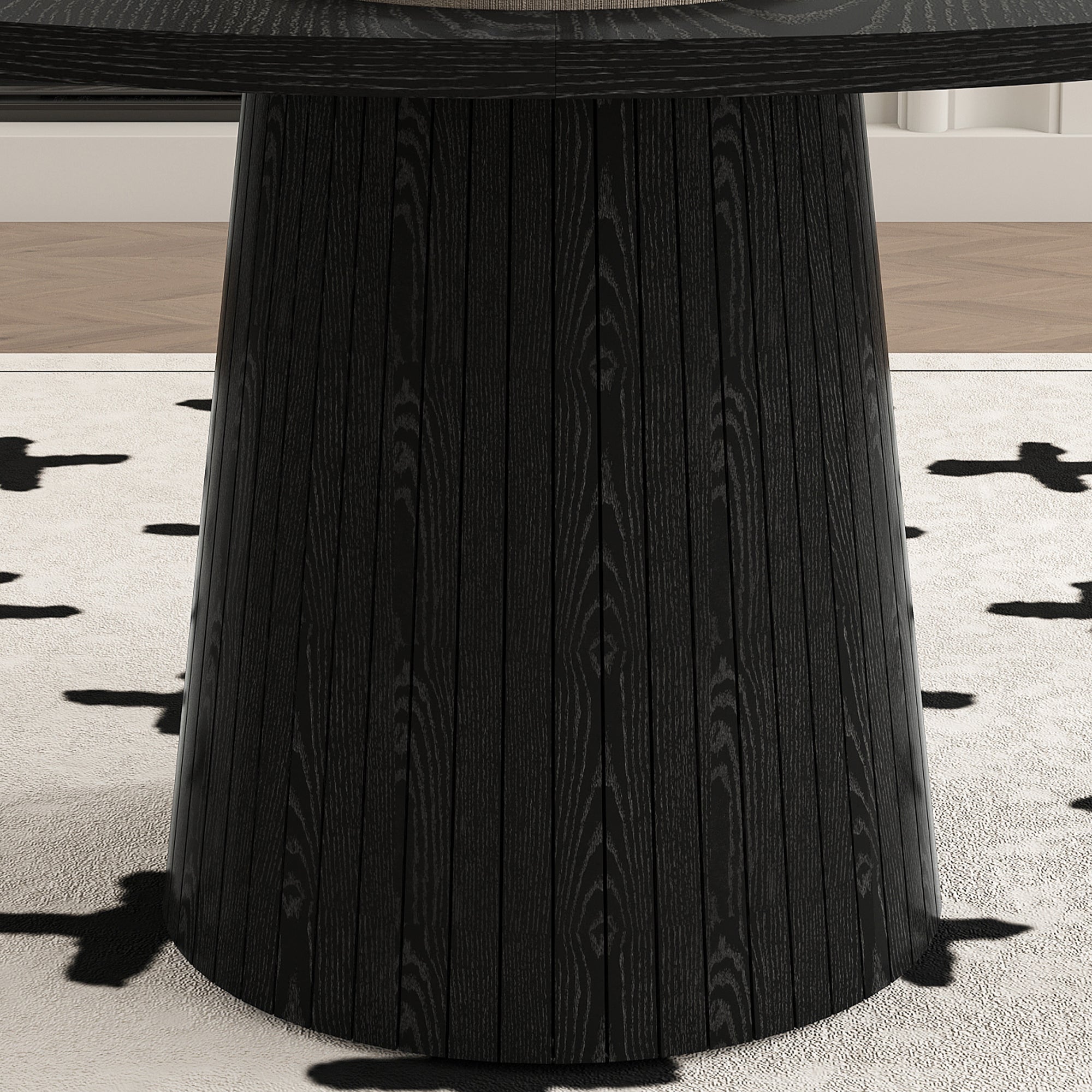 Close-up of the slatted conical black pedestal base on a cross-pattern rug