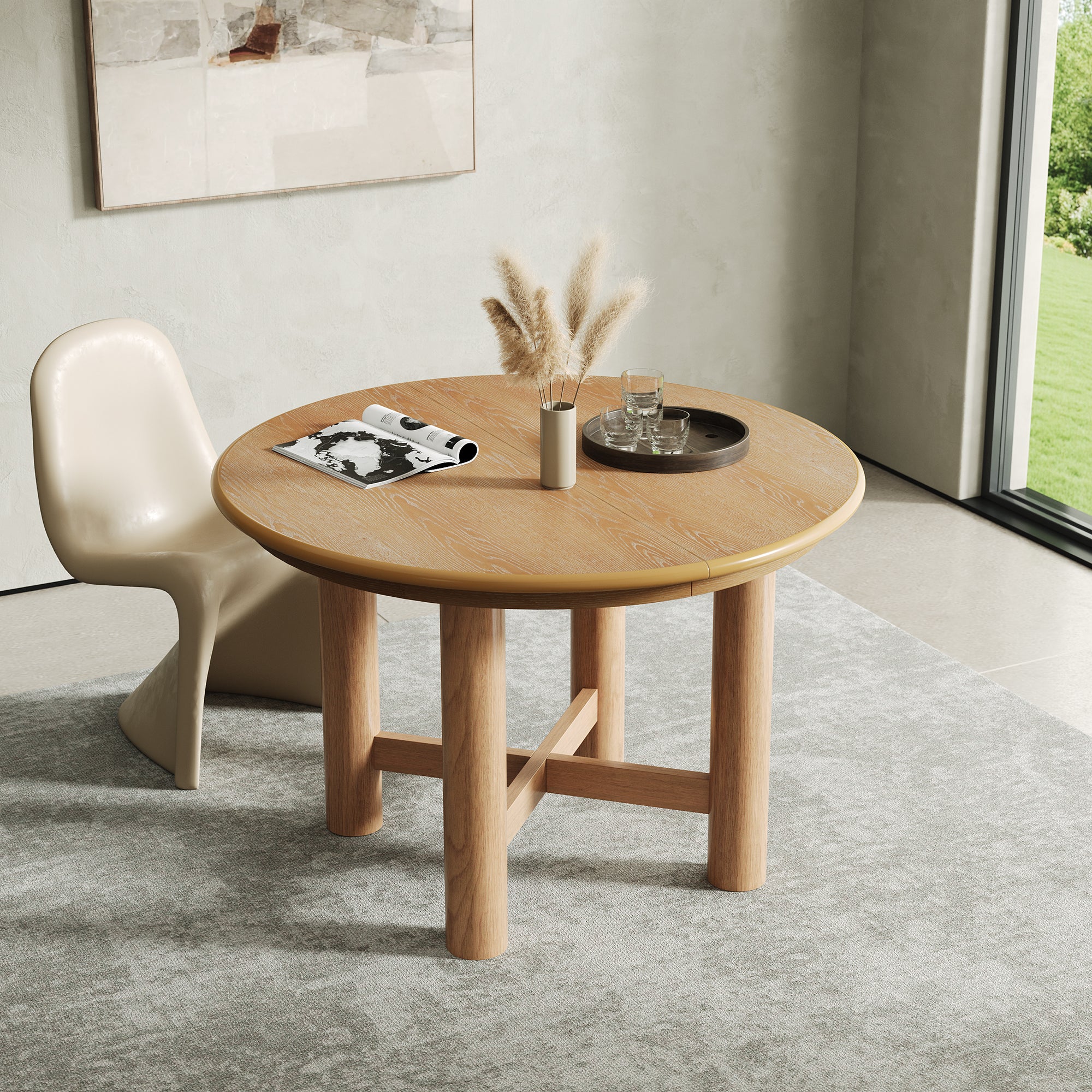 Round closed oak-veneer dining table with a single cream chair beside a garden window