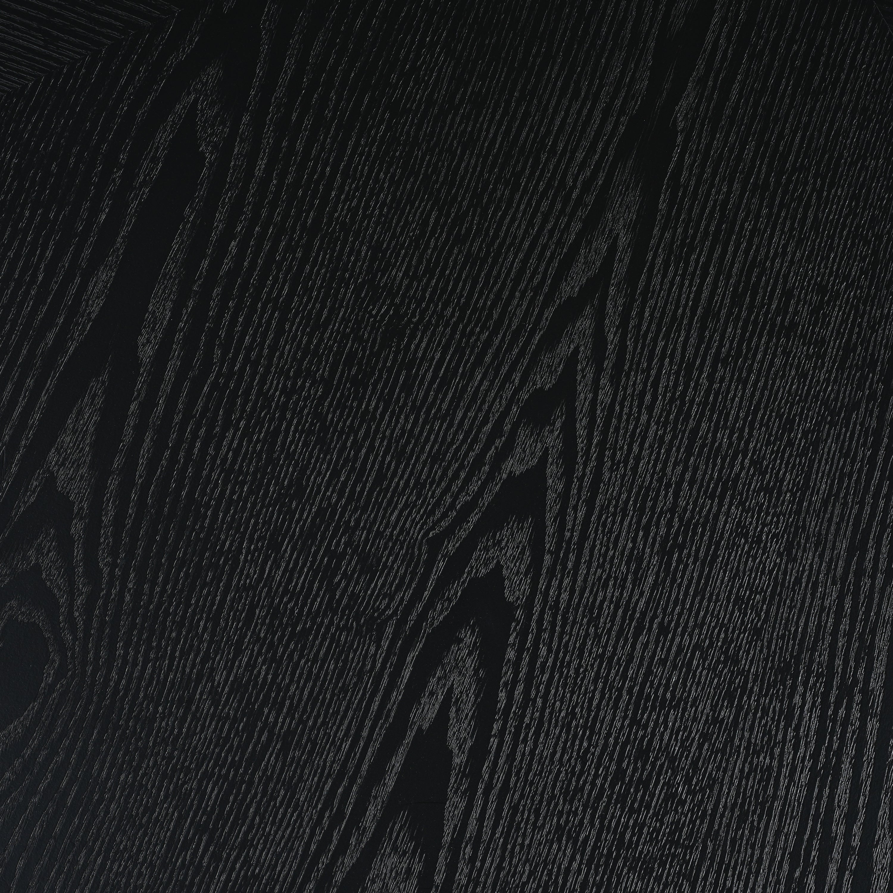 Close-up of the black wood-grain finish on the tabletop