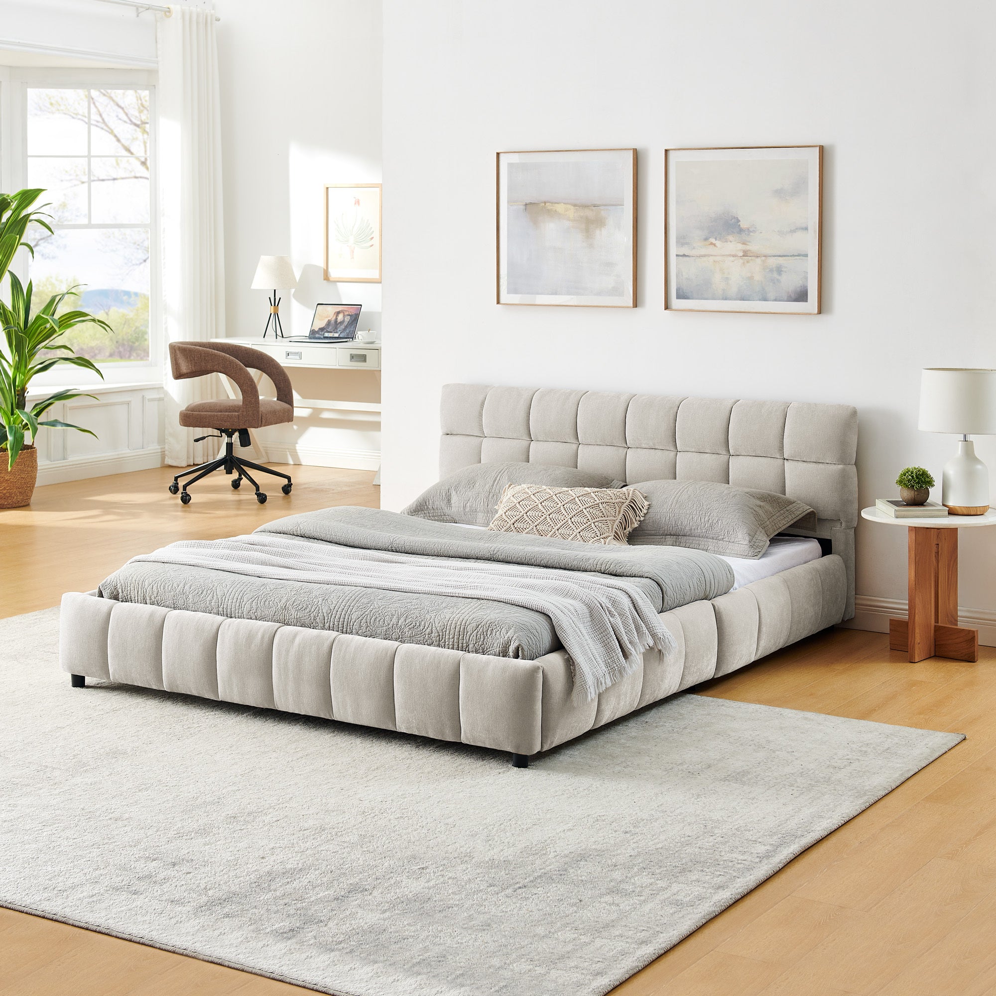 Angled view of the beige chenille queen platform bed, tufted headboard and channel-tufted footboard, styled