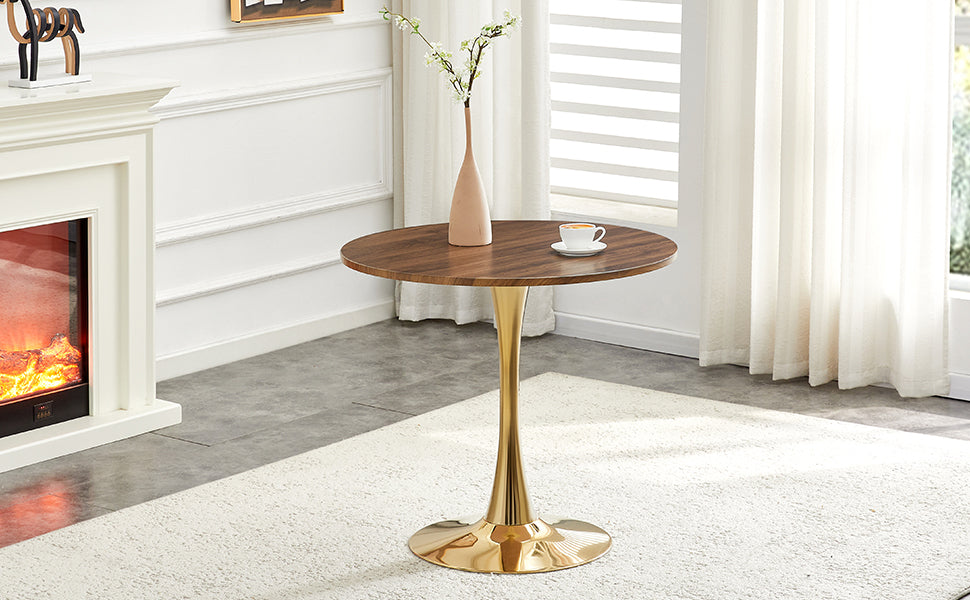 Walnut round dining table with gold pedestal near a fireplace with a vase and coffee, angled room view