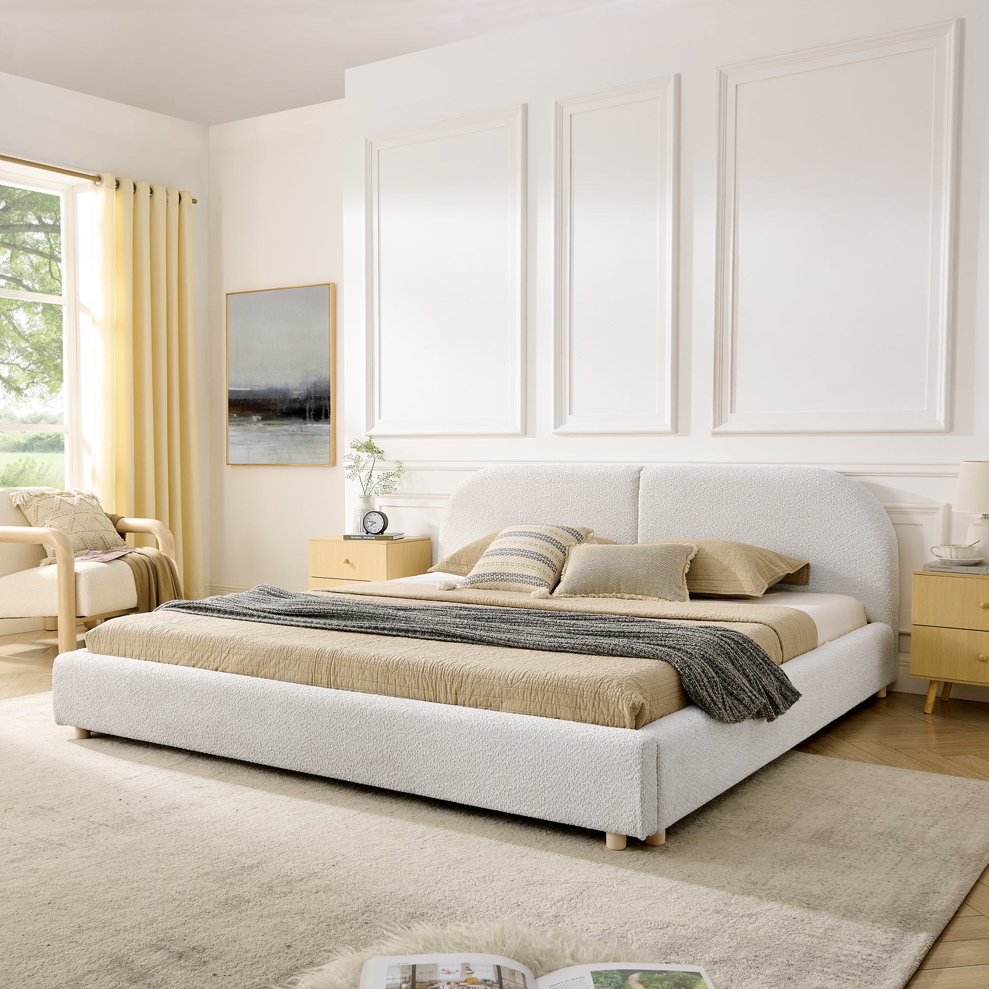 Beige upholstered king bed with curved headboard in a bright bedroom