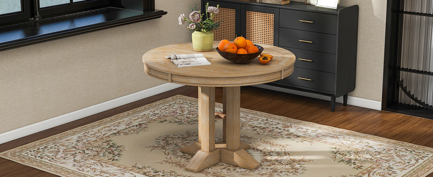 Natural oak round dining table styled by a window in a bright room
