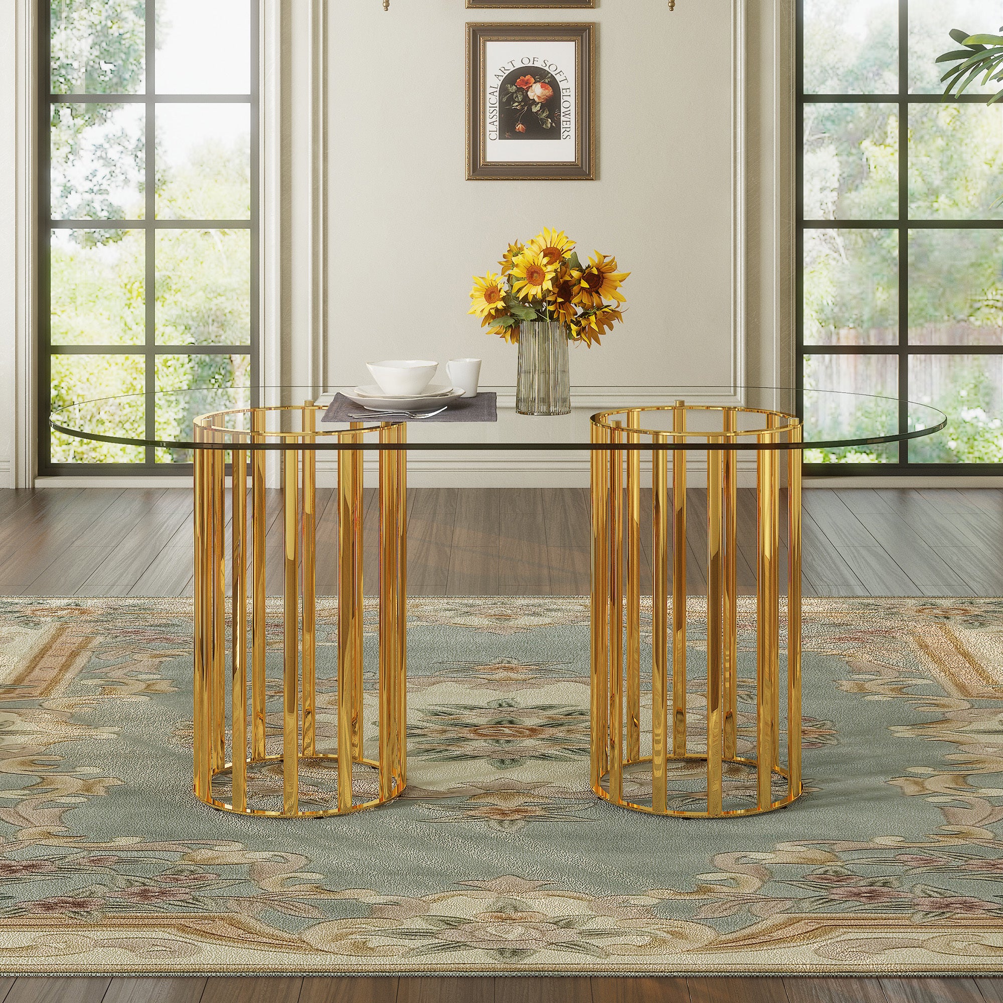 Front view of oval glass dining table with gold double-column base, styled with dishware and sunflowers in a bright room