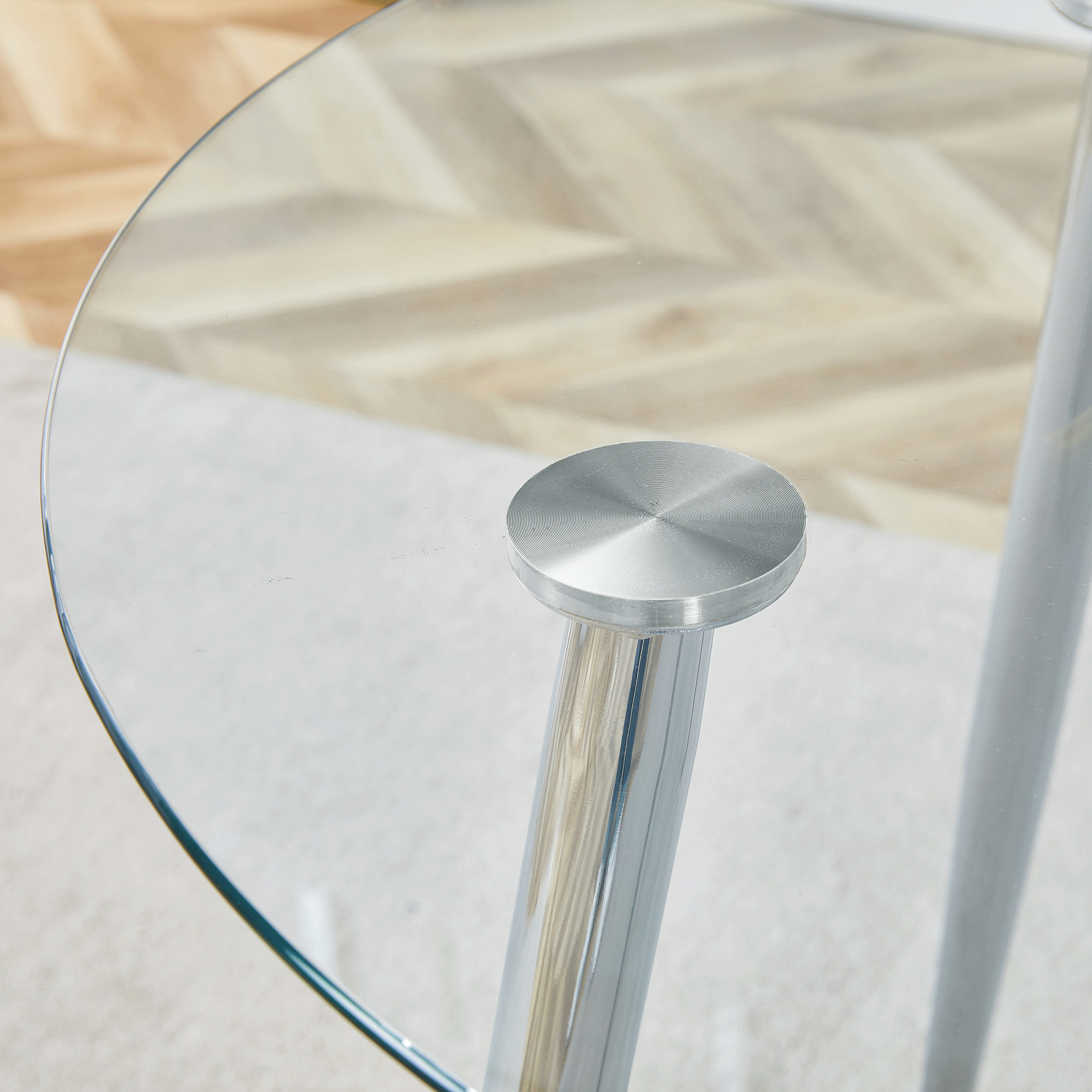 Overhead close-up of the glass tabletop edge and brushed metal suction-cup leg top