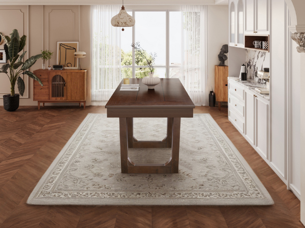 Angled end room view of the walnut dining table centered on a patterned rug