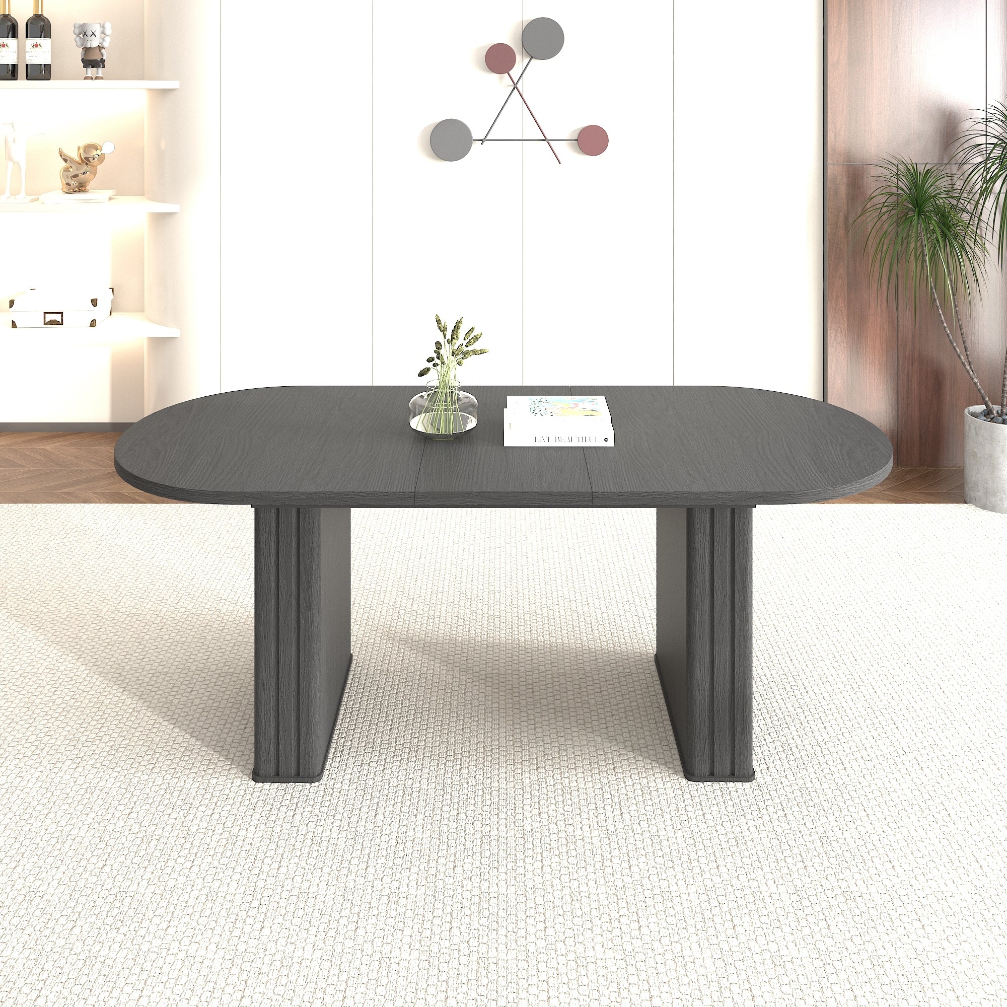 Front view of the black oval extendable dining table on a woven rug in a modern room