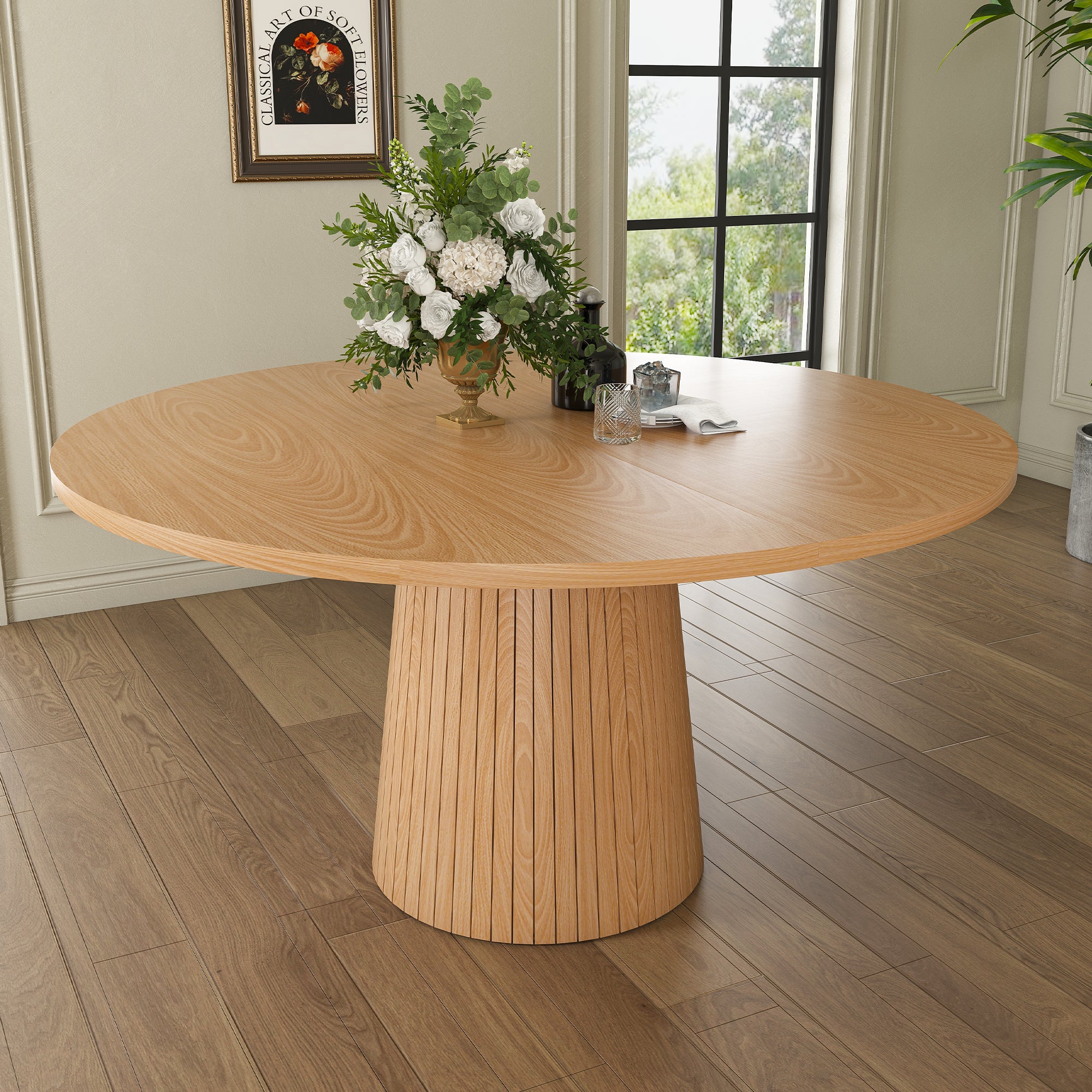 Oak round farmhouse dining table styled with white roses in a bright dining room by a window
