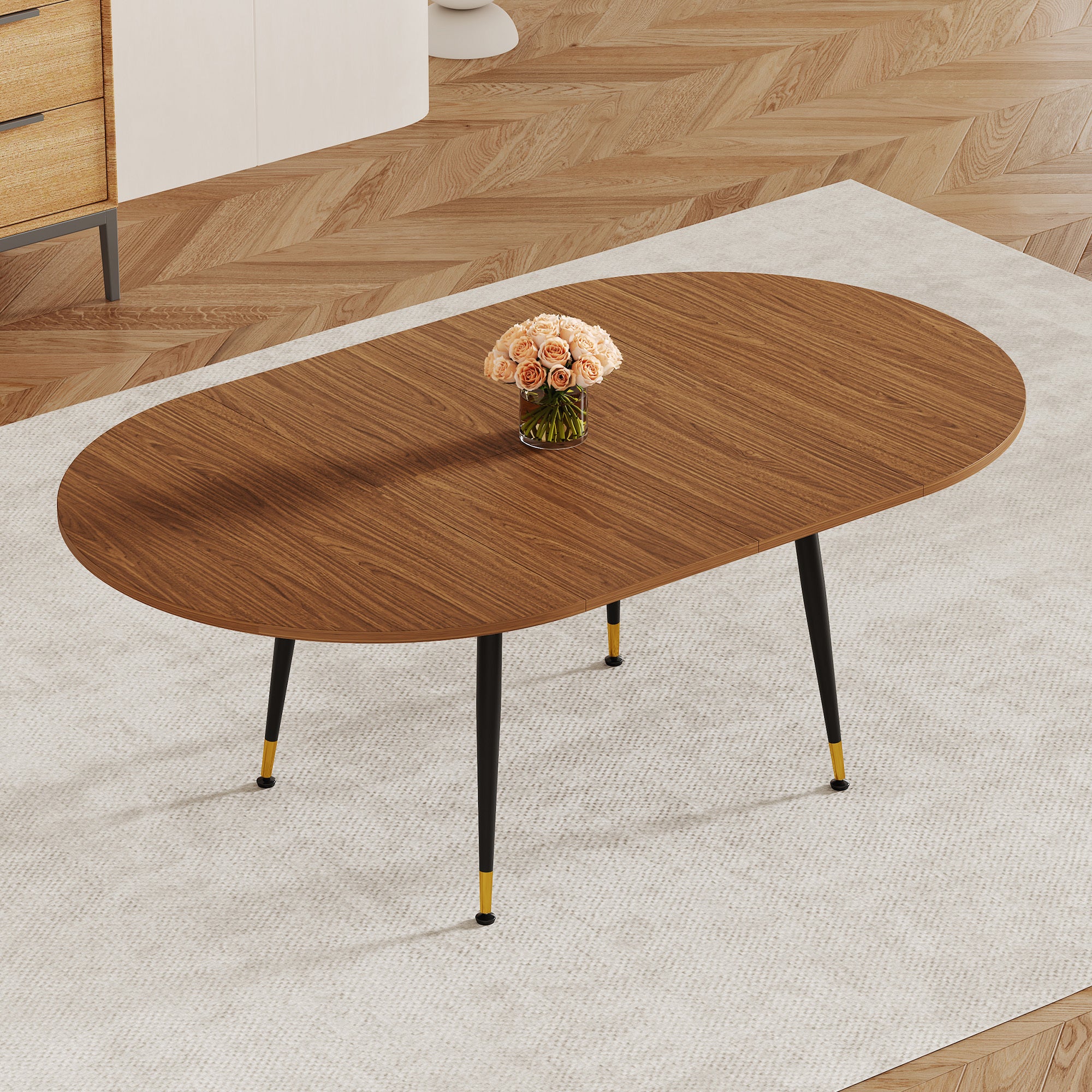 Overhead view of walnut-tone oval extendable dining table with black tapered legs, roses on top