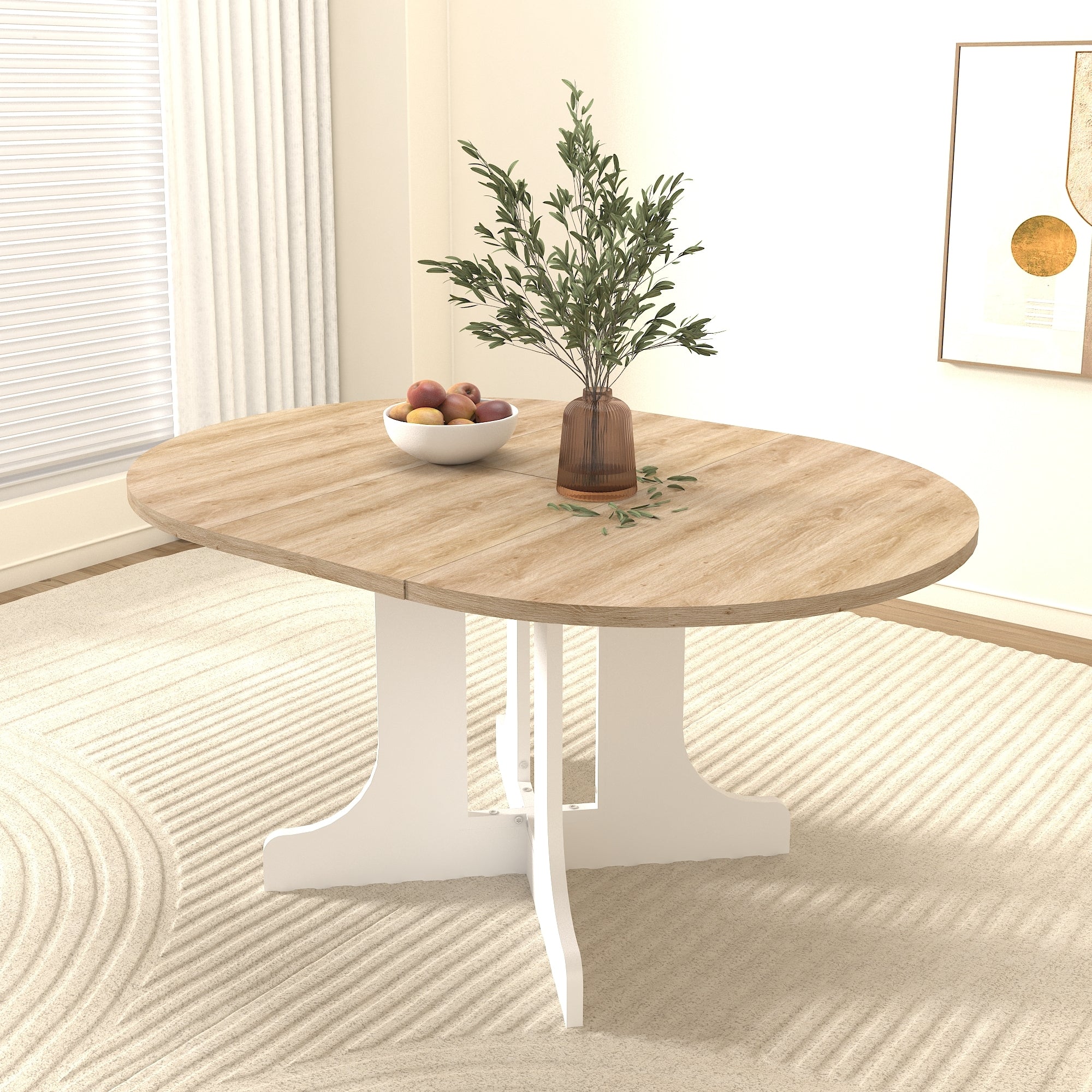 Round oak-top dining table with white pedestal base, three-quarter view with a plant and fruit bowl