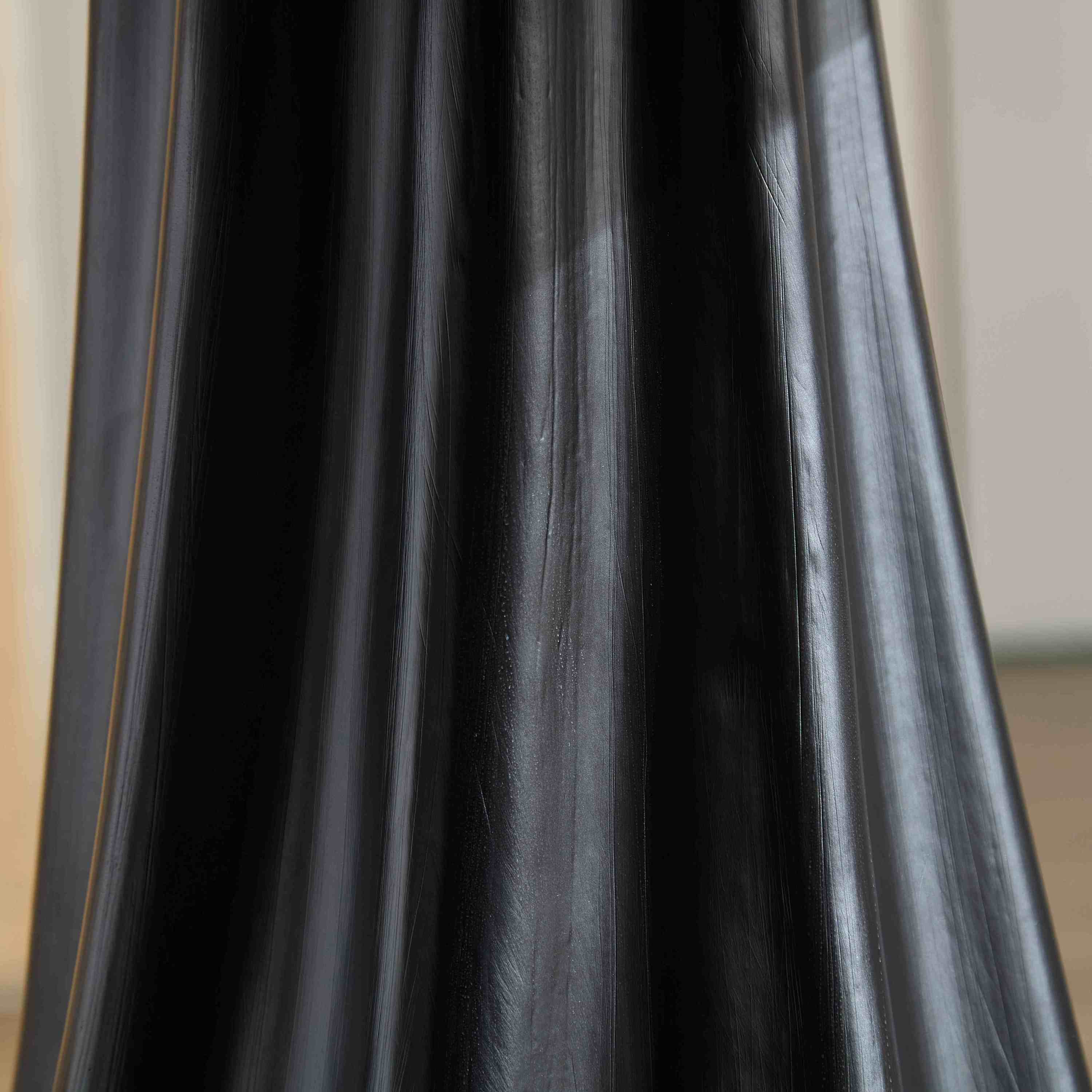 Extreme close-up of the brushed black fluted column of the petal dining table
