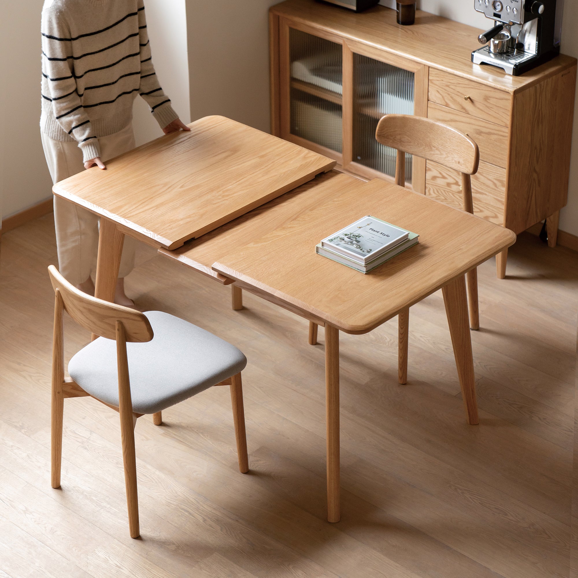 Natural oak table pulled apart at the center gap to show the extension in a styled room