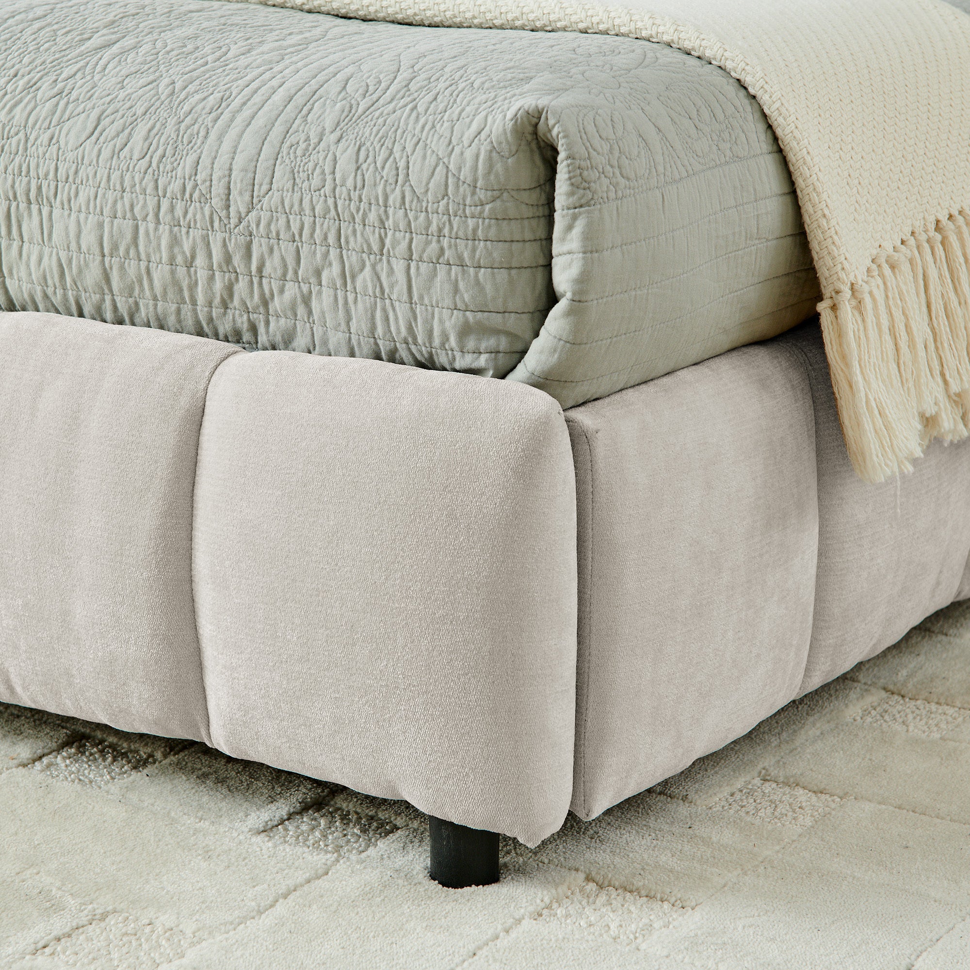 Close-up of drawer caster wheel and beige chenille side panel