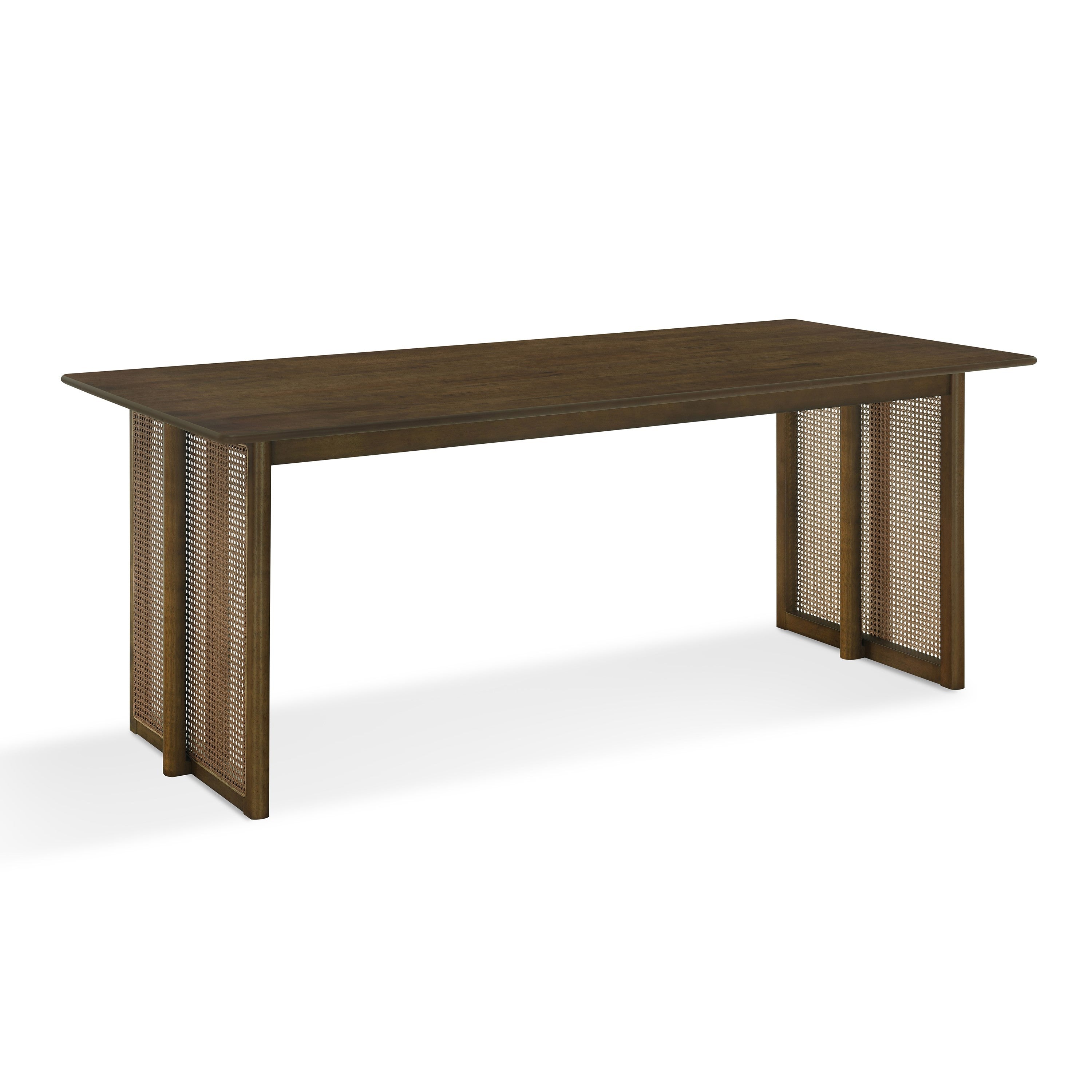 Three-quarter studio view of the walnut solid rubberwood dining table with woven cane panel legs, white background