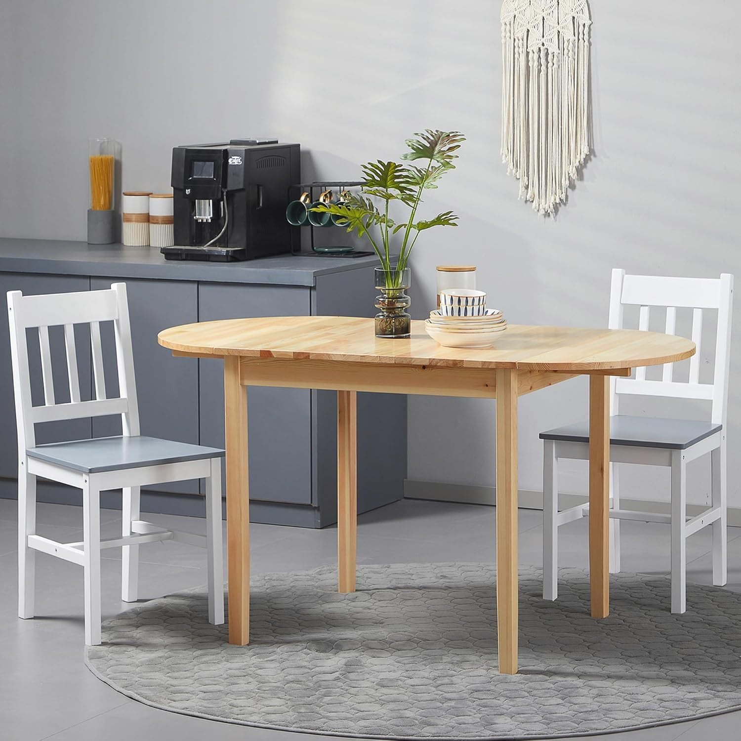 Natural pine folding drop-leaf dining table with two white chairs in a gray kitchen