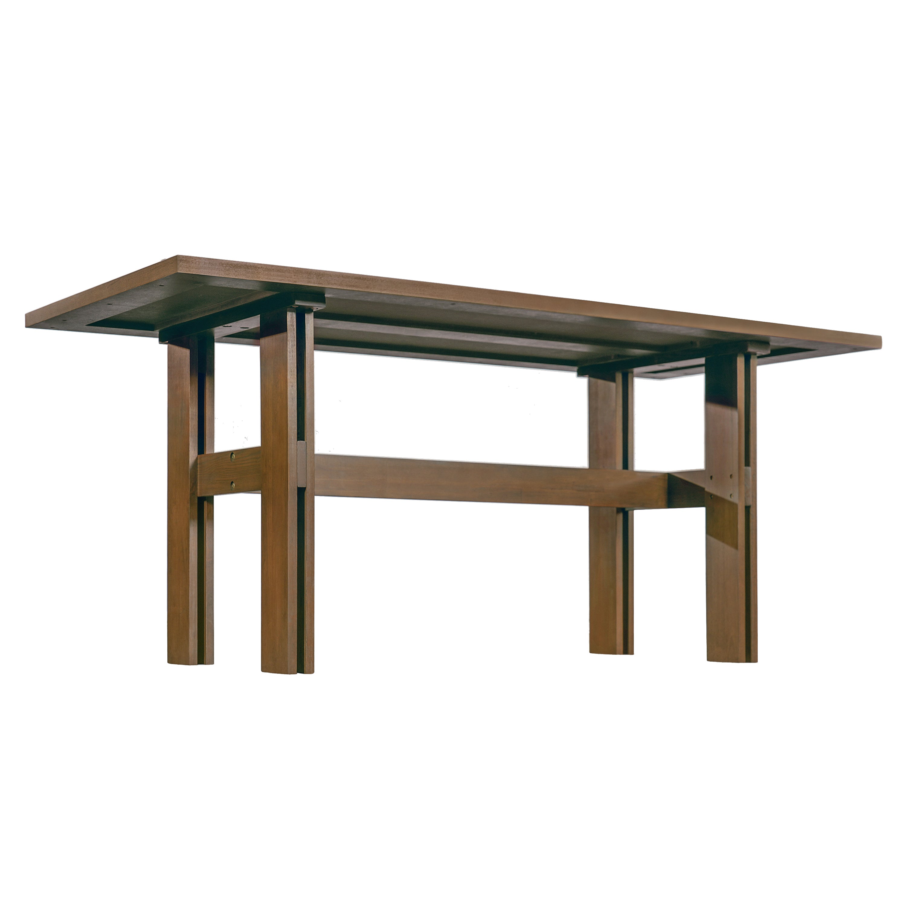 Low angled studio view showing the trestle base and crossbar stretcher of the walnut-tone dining table