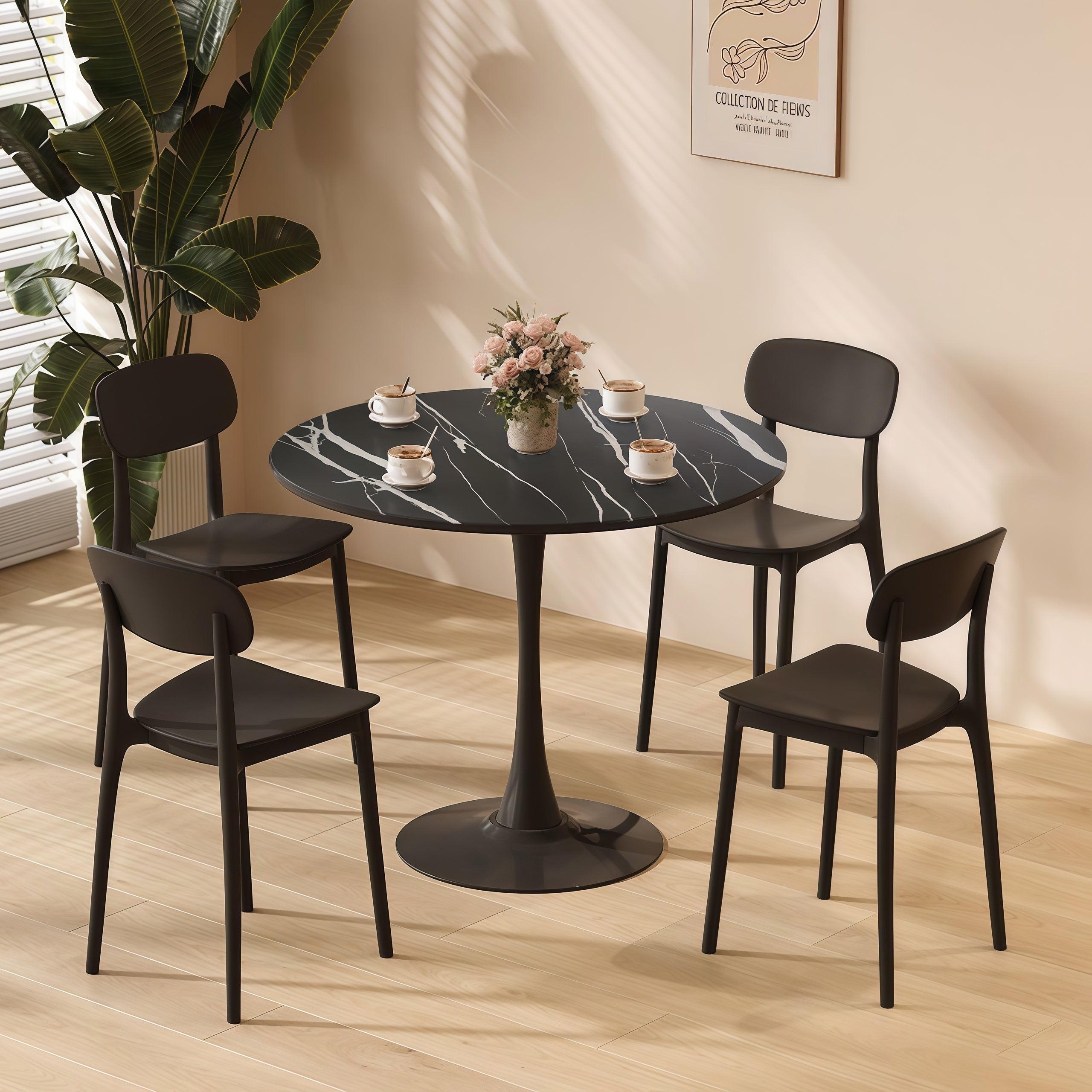 Styled dining set with black marble round table and four black chairs by a window