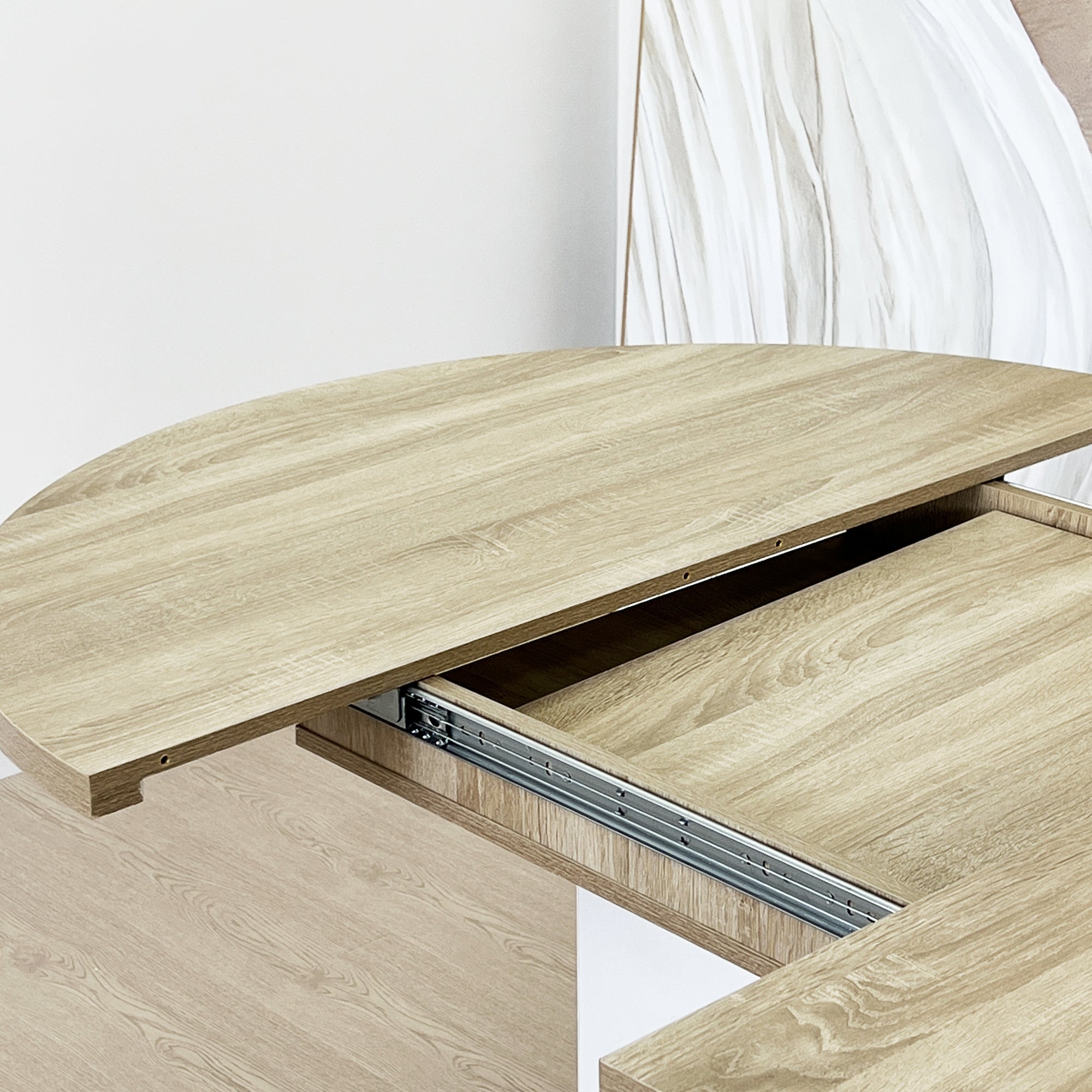 Close-up of the oak tabletop half pulled out on its metal extension slide rail