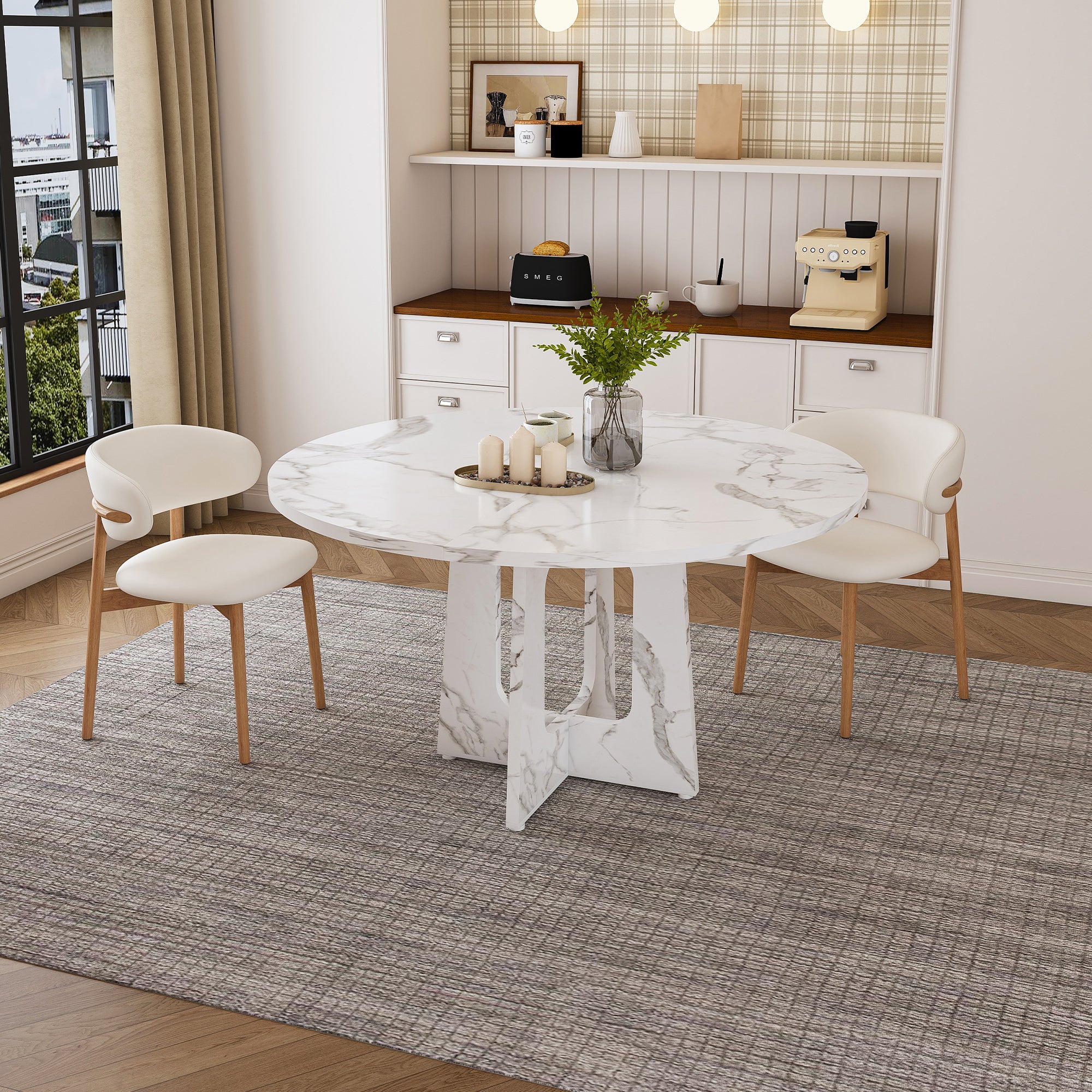 White faux marble round dining table with two cream chairs in a styled dining room, front view